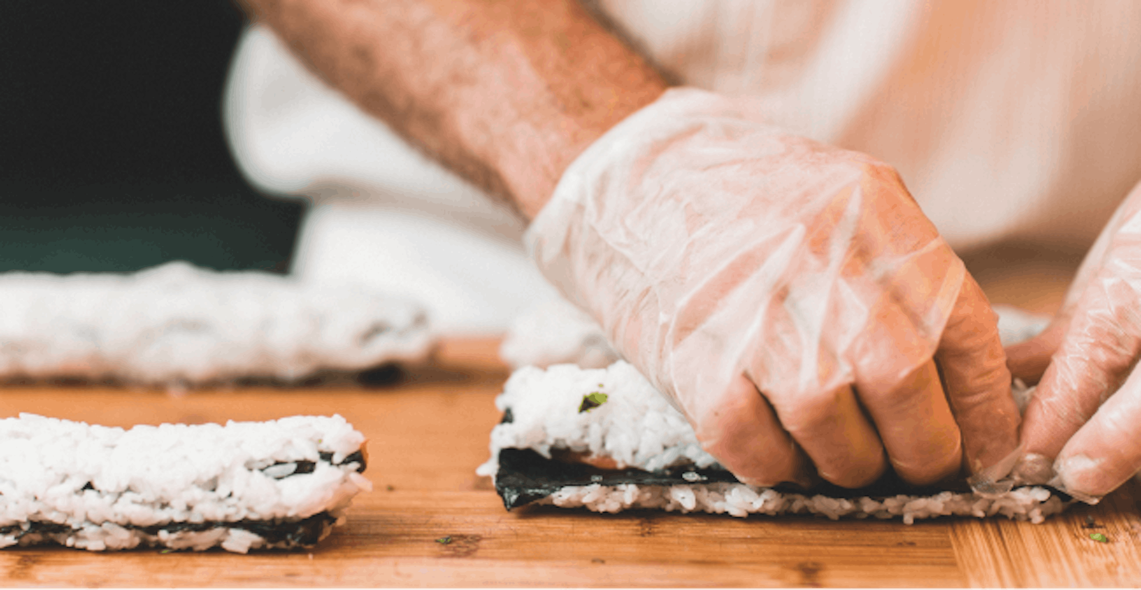 Image of a chef rolling sushi