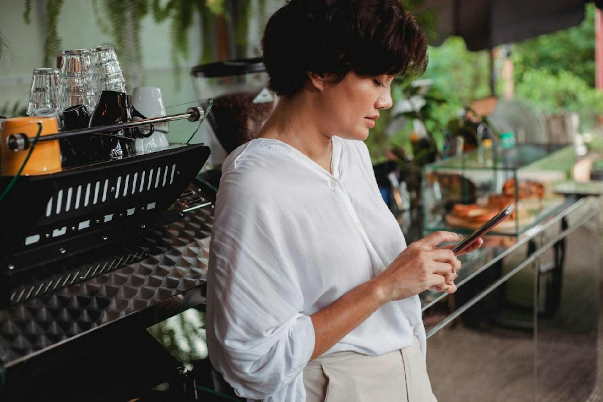 Image of a restaurant staff looking at her phone