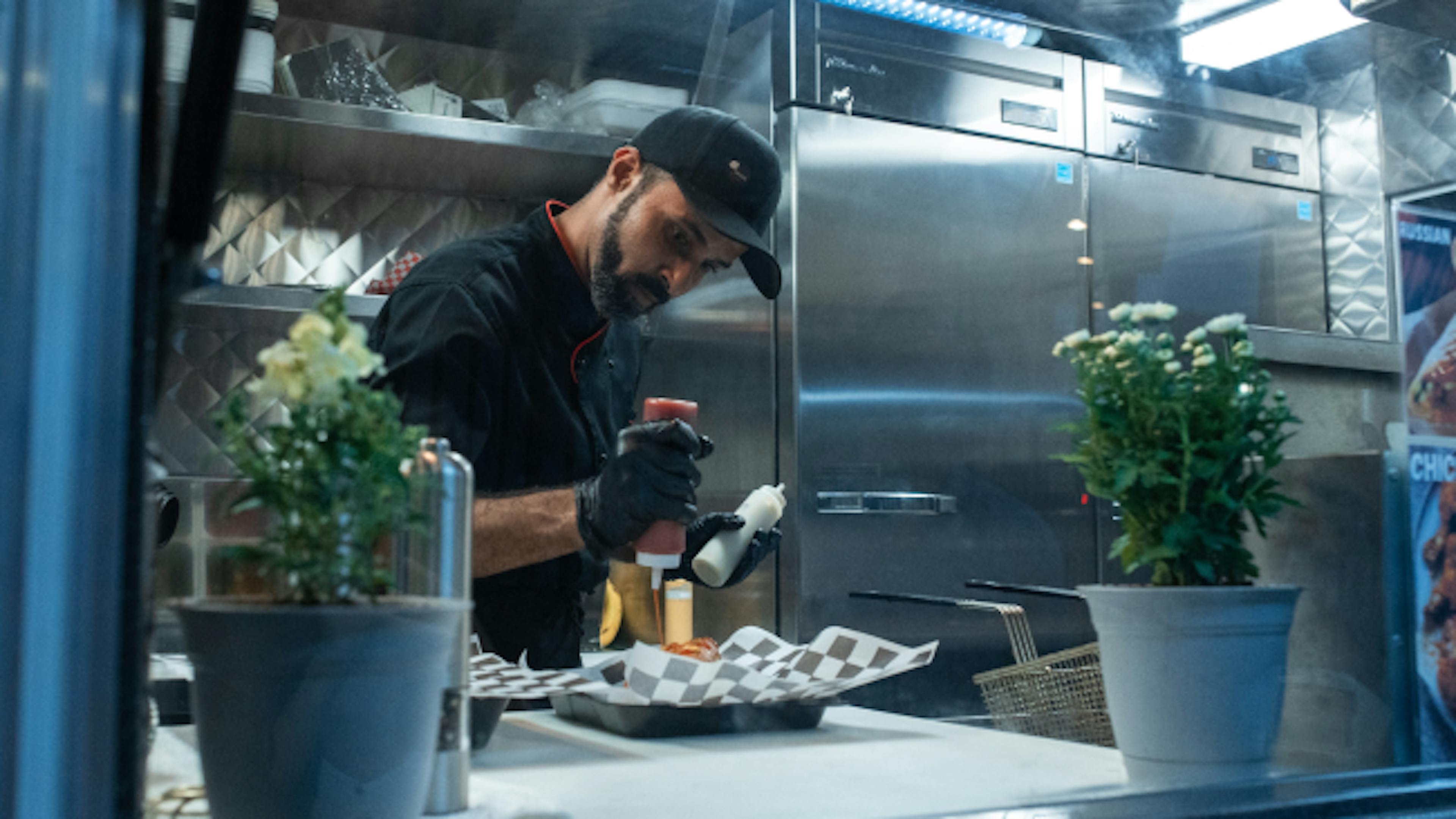 Image of a chef putting sauce on a dish