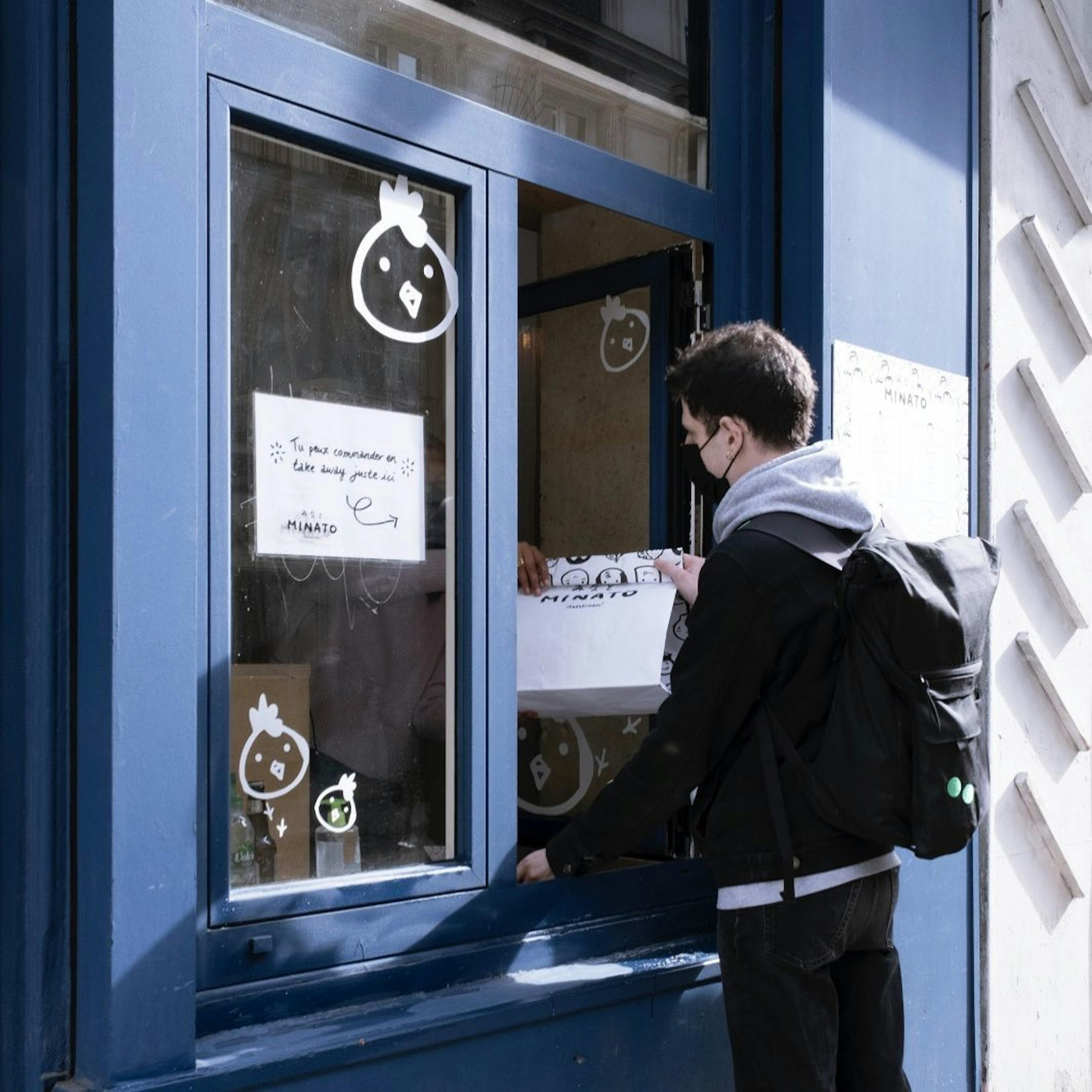 Image of a man picking up delivery from a counter