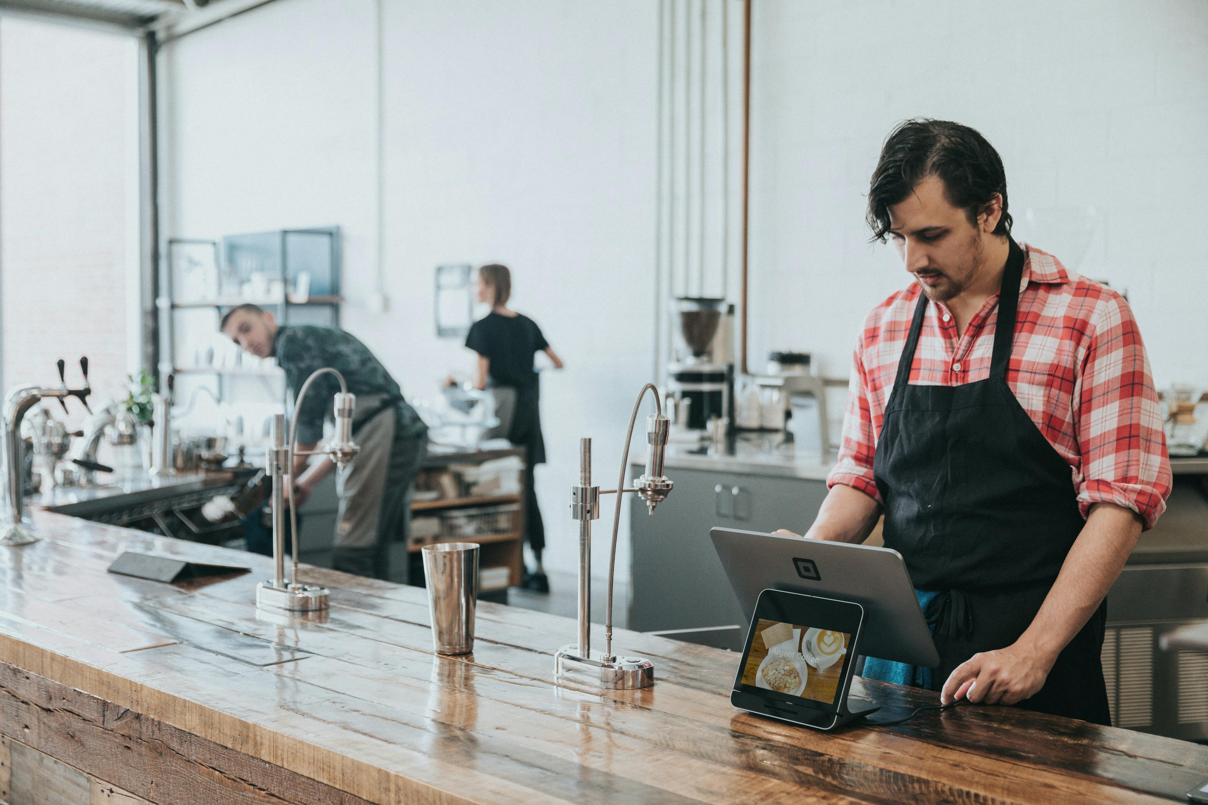 Image of a restaurant staff working over a POS terminal