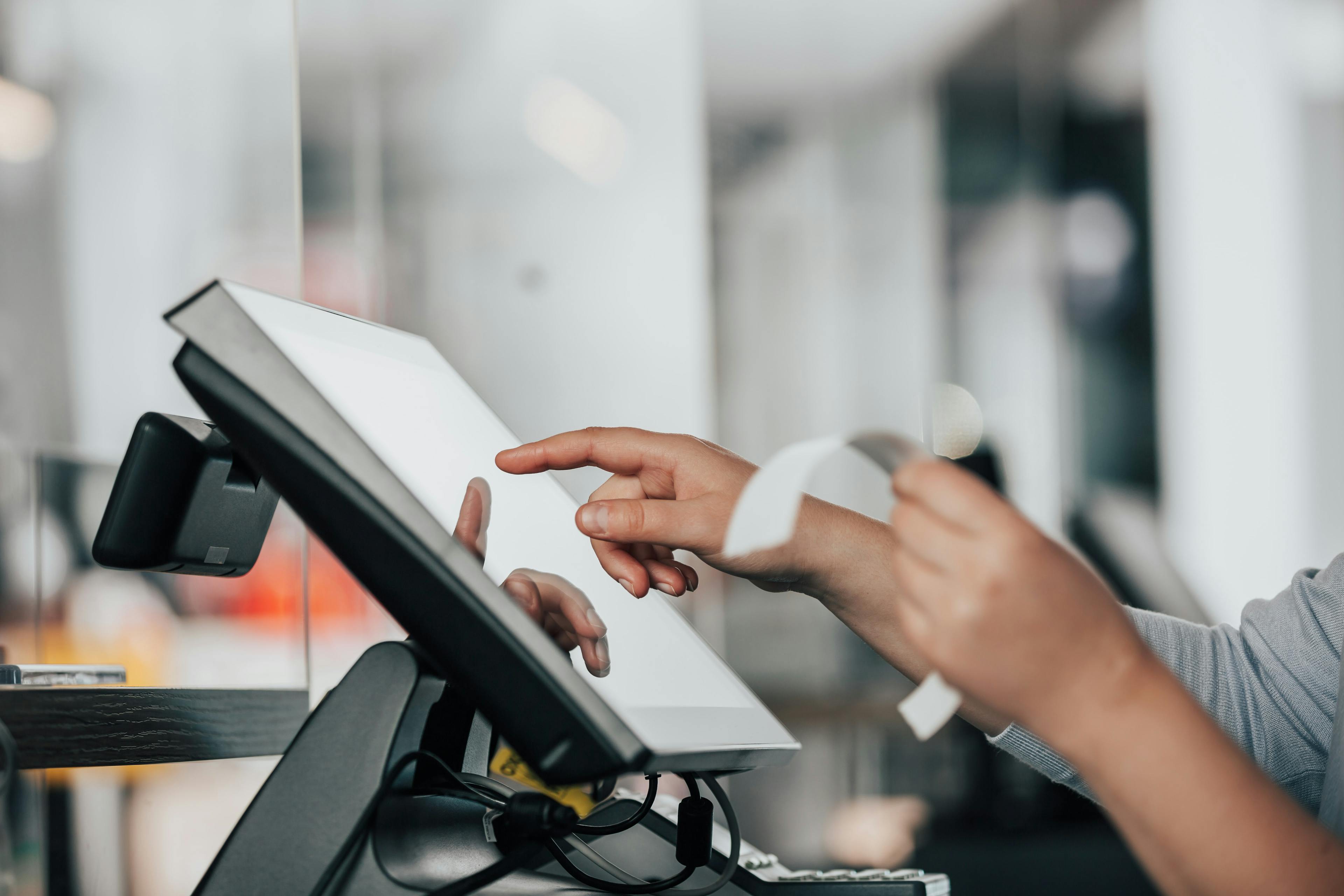 Image of a restaurant staff inputting info into a POS terminal