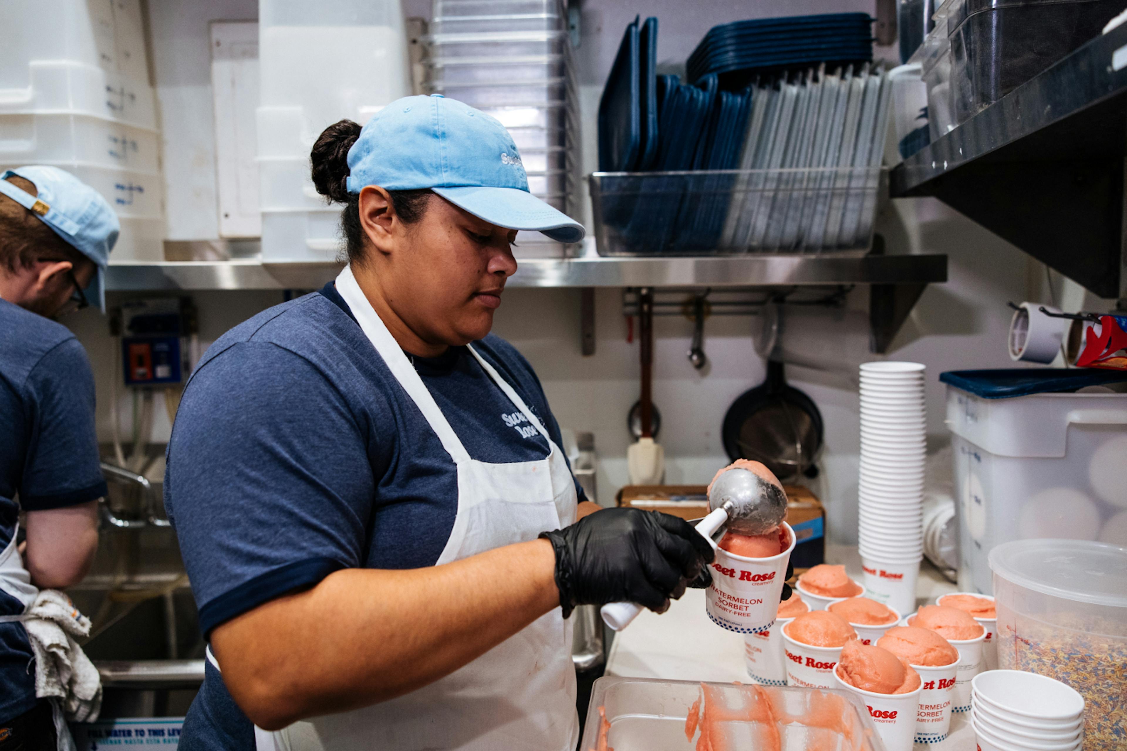 Woman scooping ice cream into to-go container