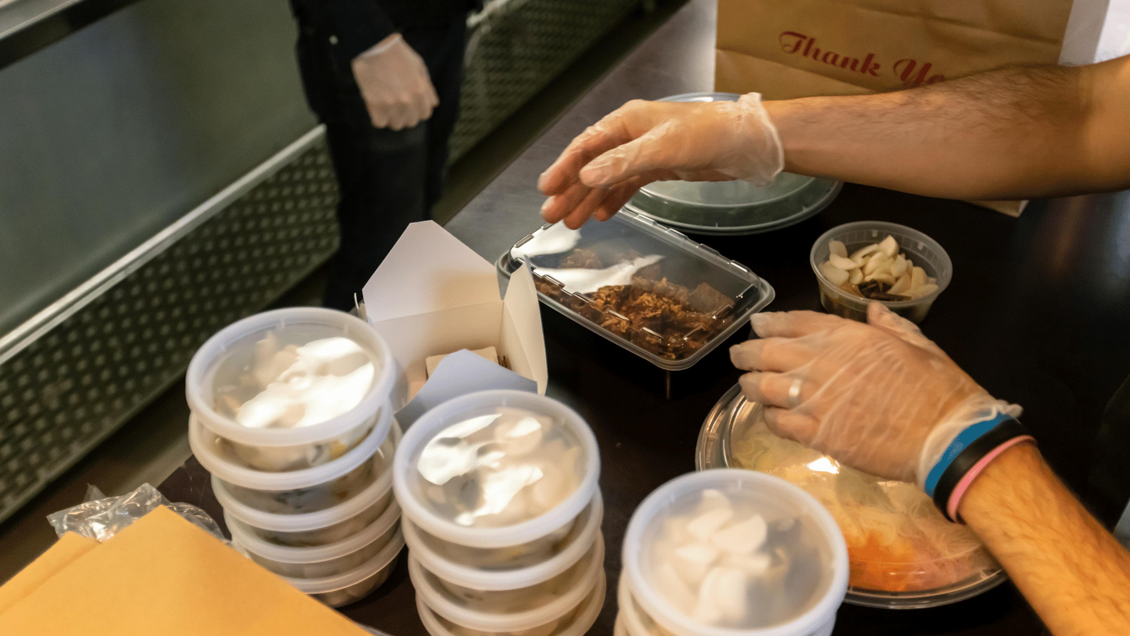 Image of a restaurant employee packing delivery orders