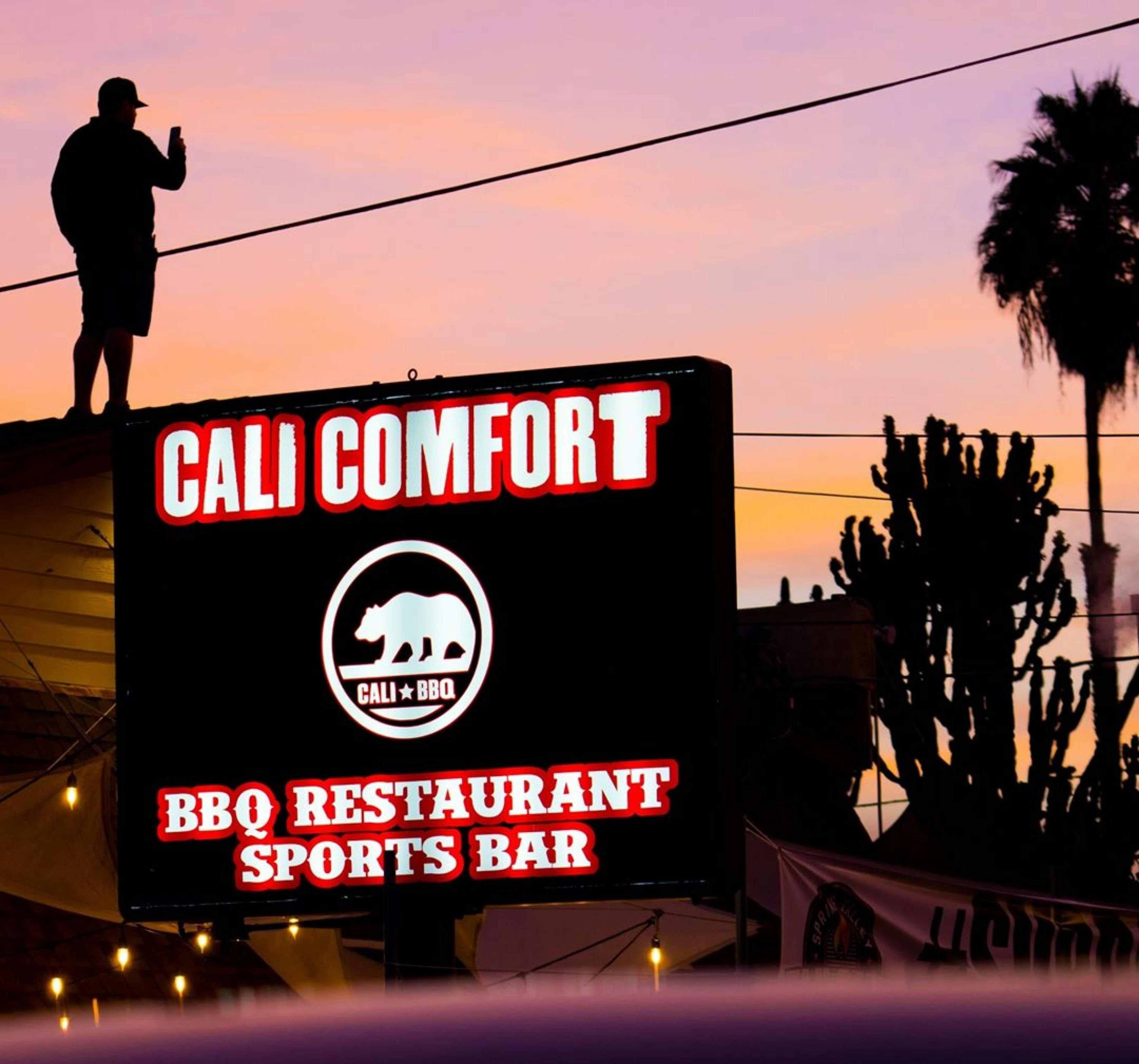 Image of Cali BBQ's sign with the sunset in the background