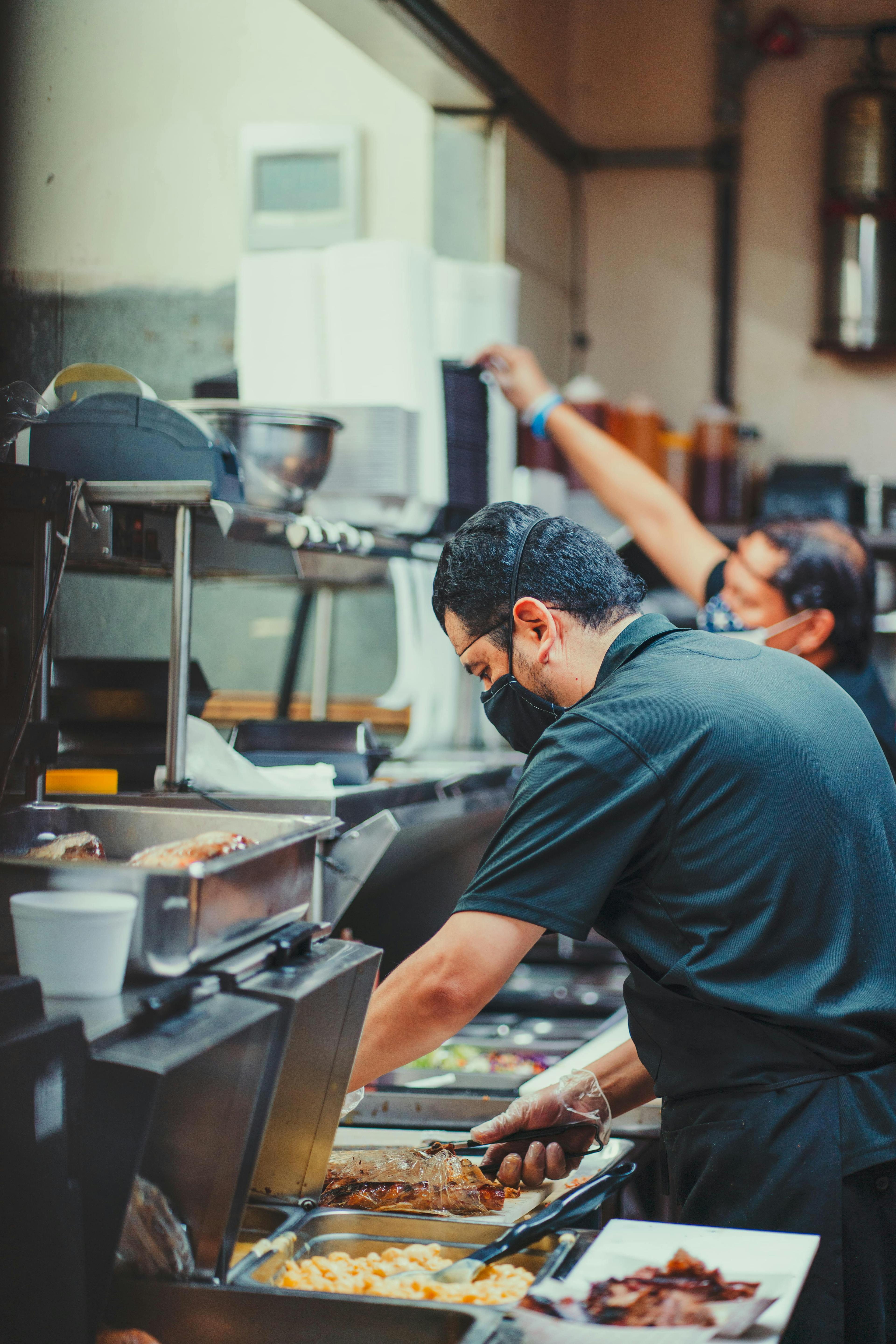 Image of Cali BBQ employees preparing plates on the line