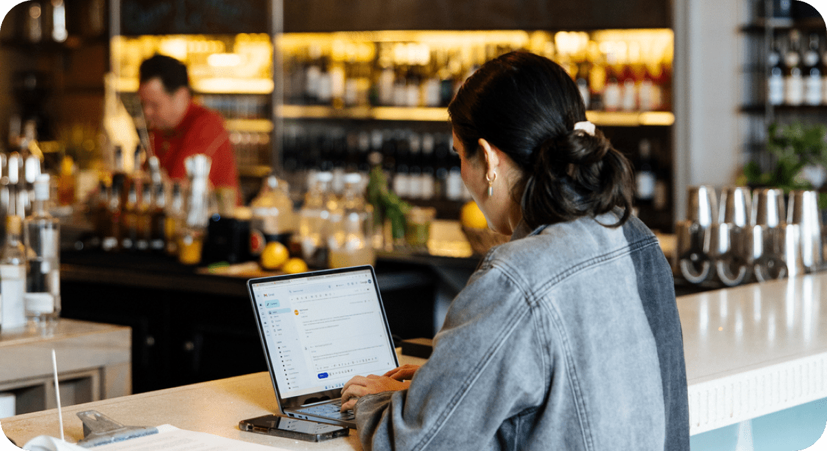 A woman using a computer at a restaurant.