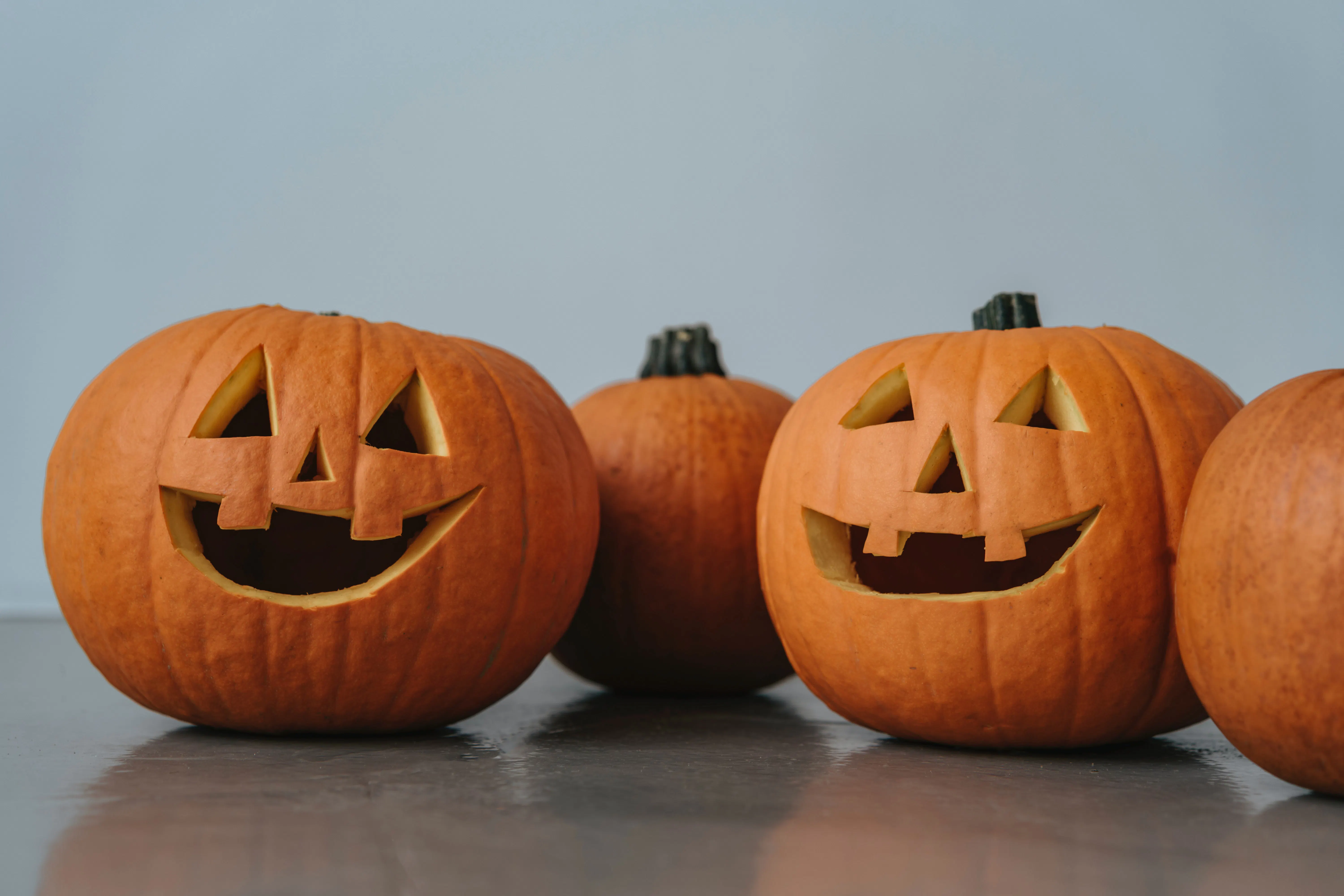 Image of three Jack-O-Lanterns on a greyish blue background
