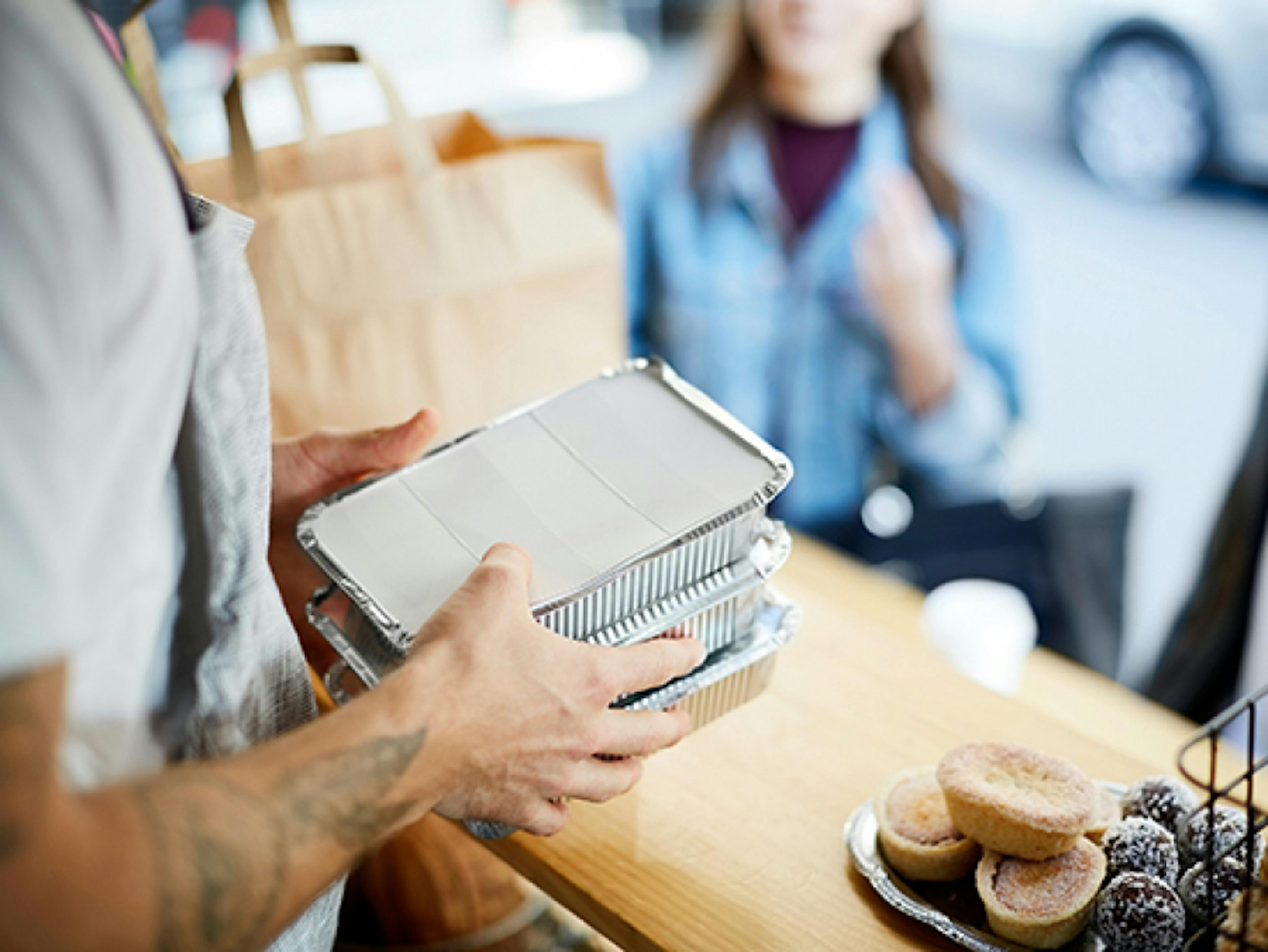 Image of a restaurant employee packing delivery orders