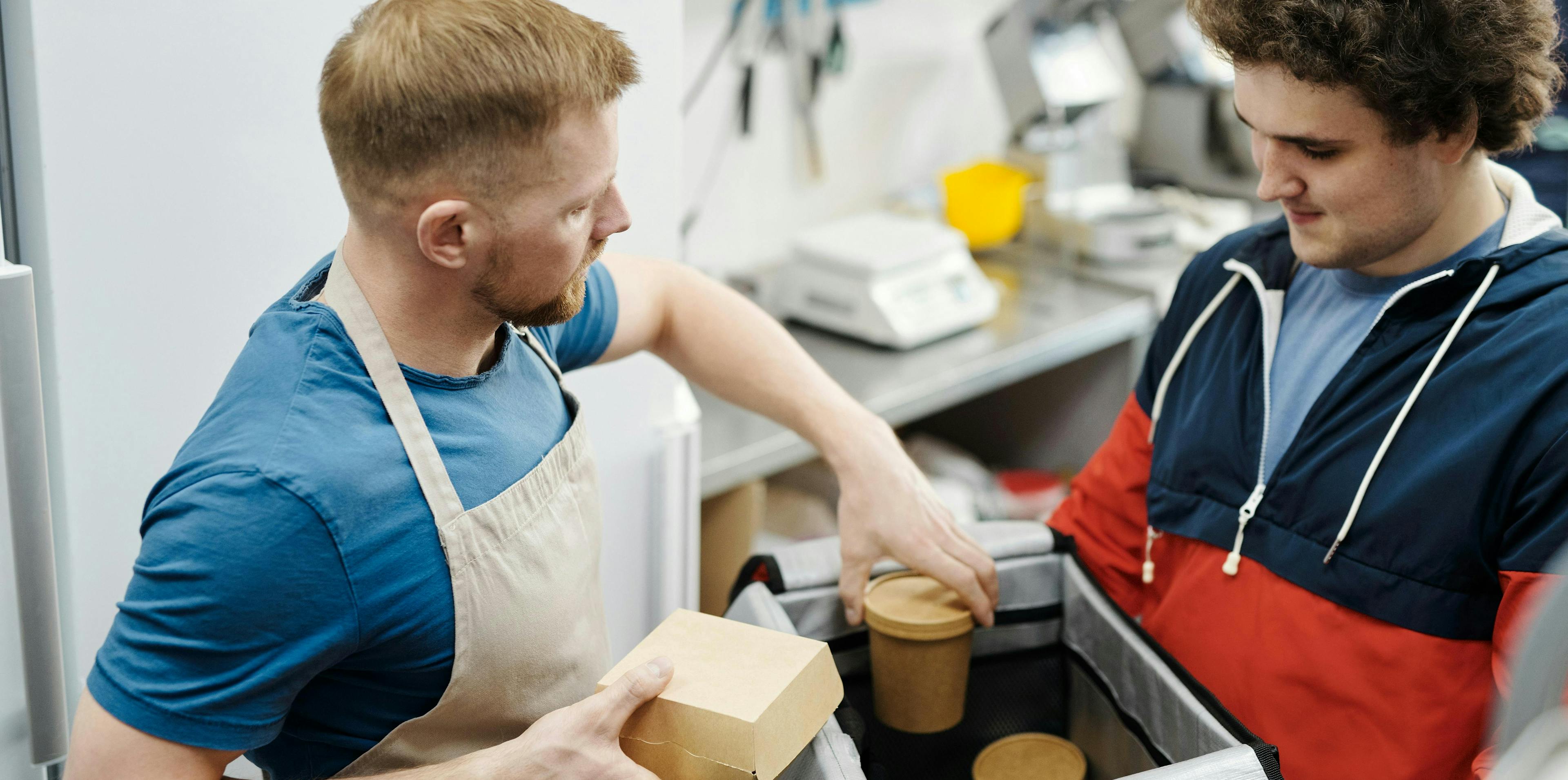 A restaurant owner loading a delivery order. 