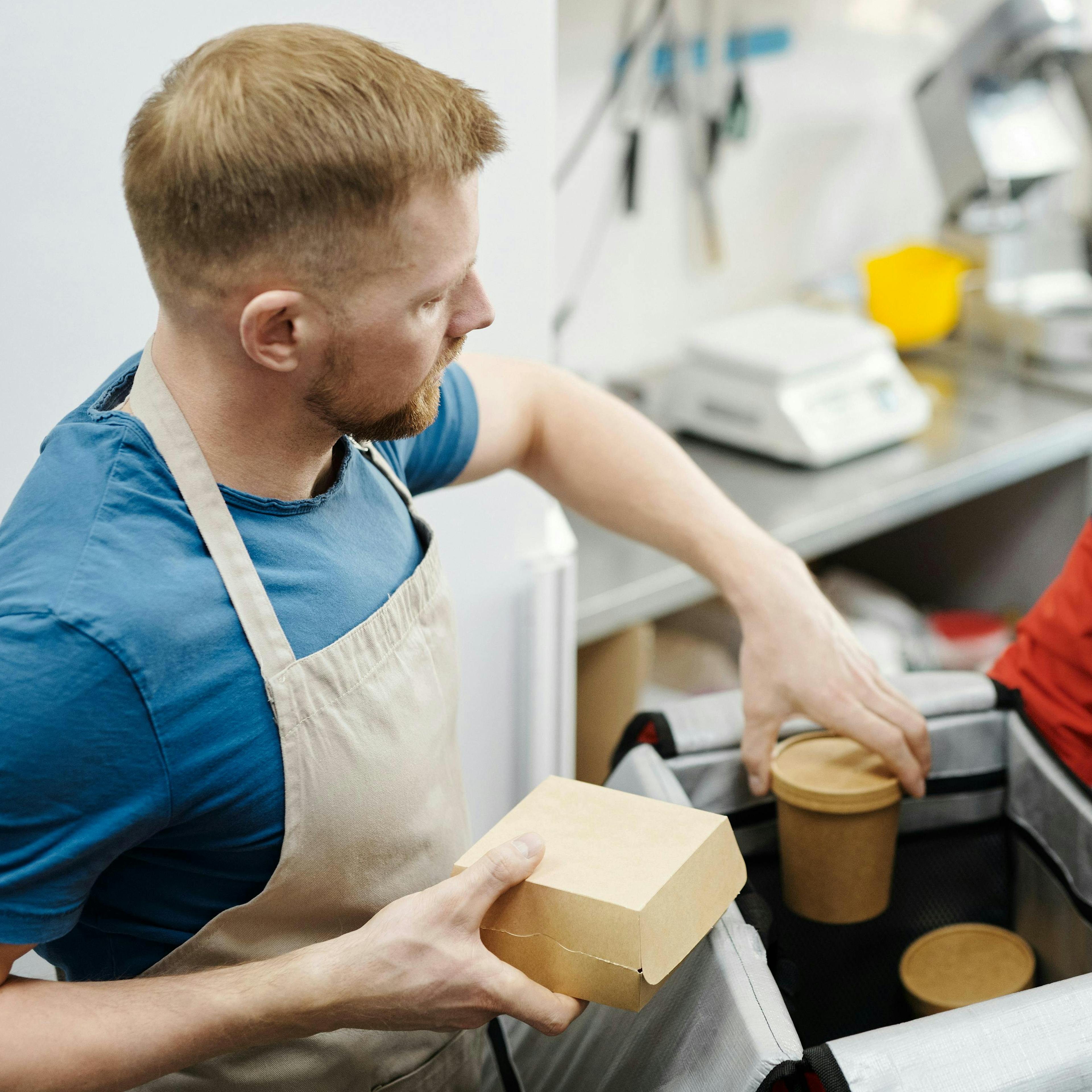 A restaurant owner loading a delivery order. 