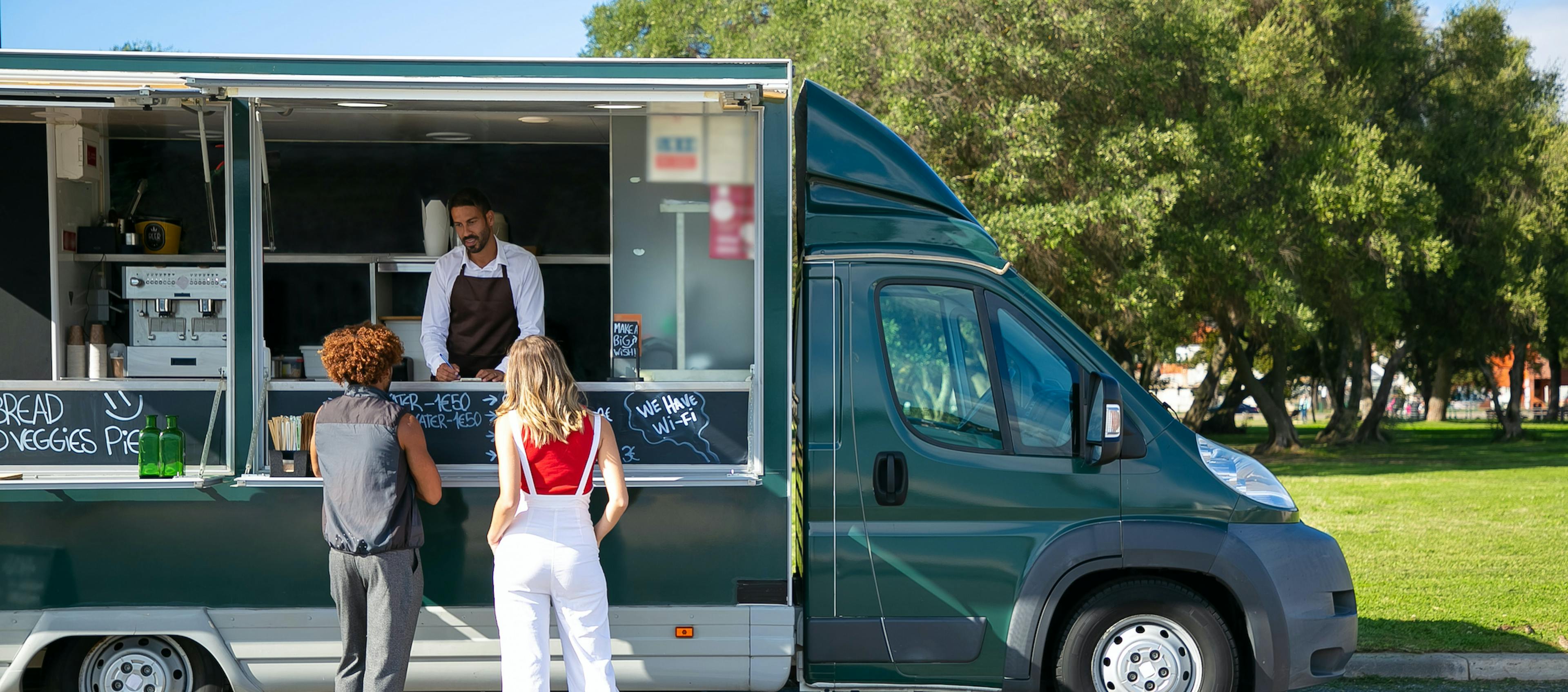 People ordering from a food truck, driving profit. 