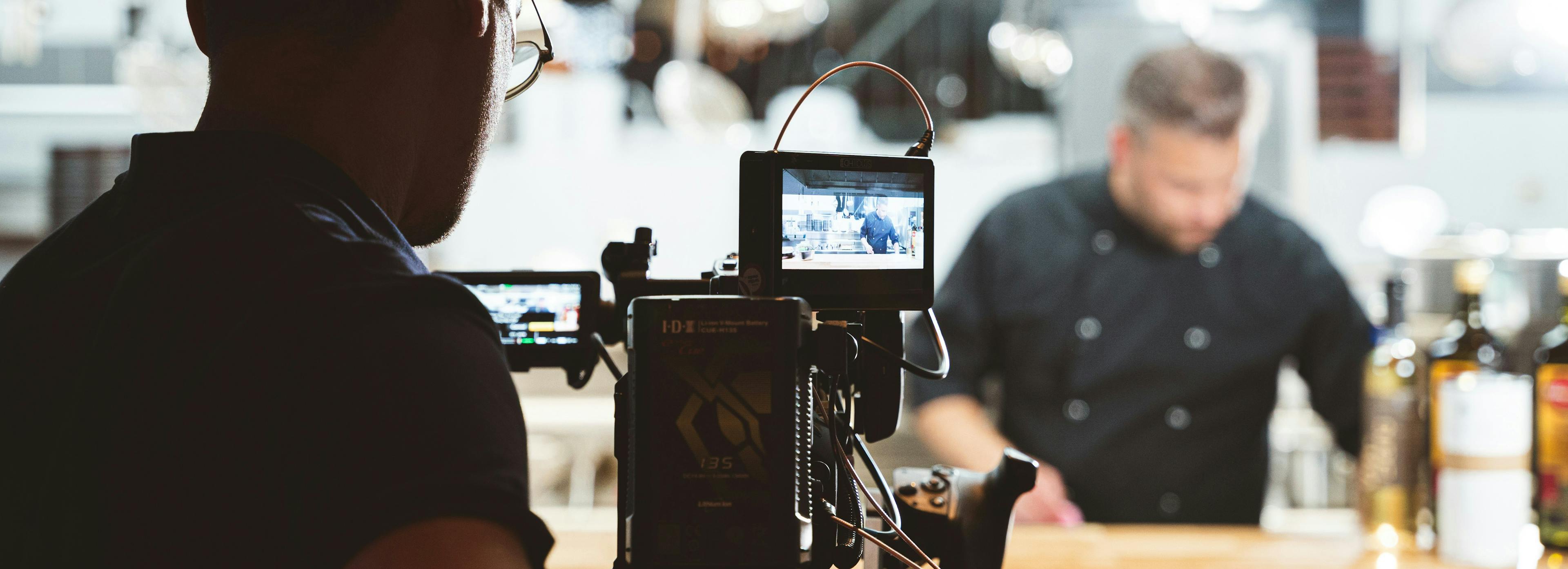 A restaurant owner being filmed for YouTube. 