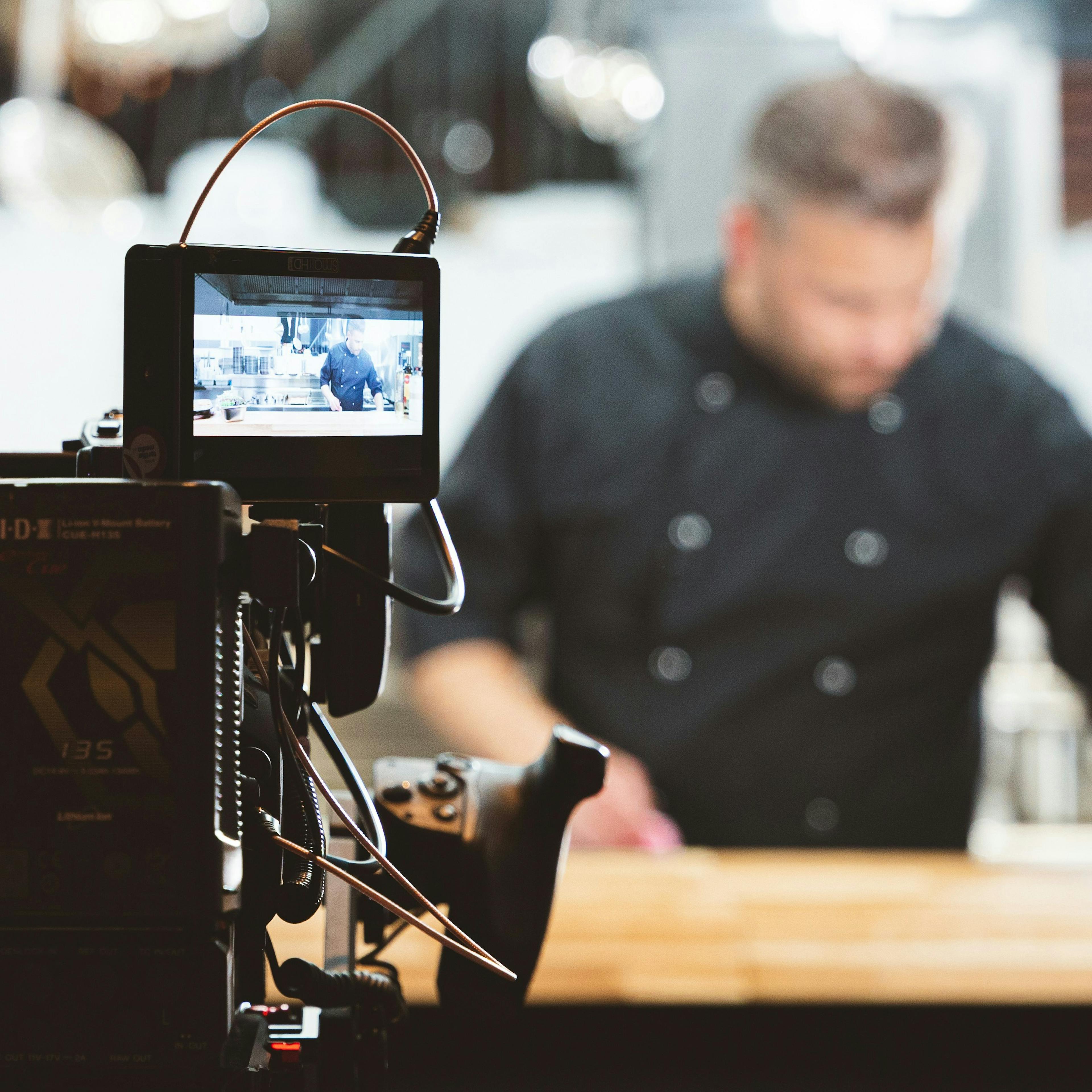 A restaurant owner being filmed for YouTube. 