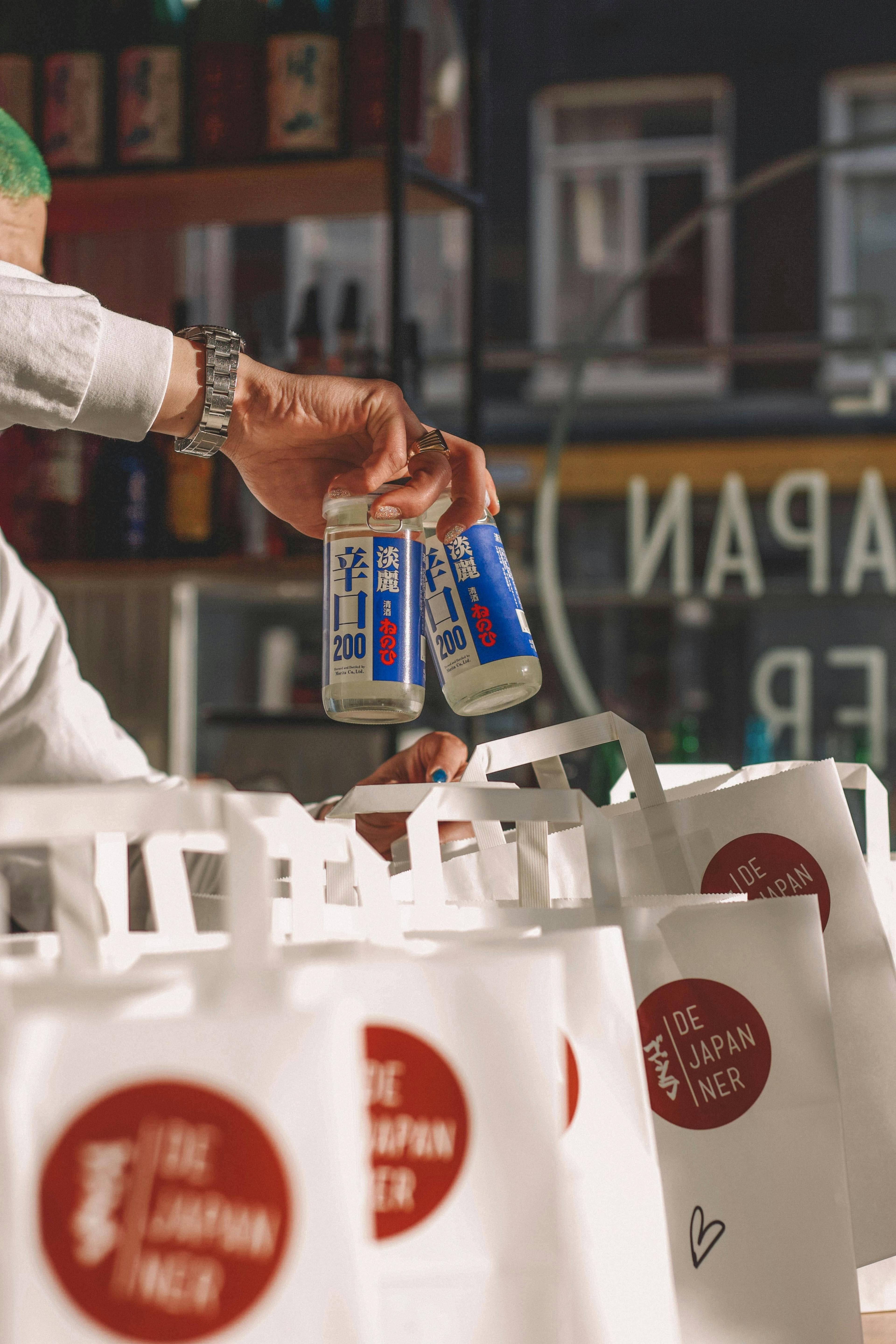 Image of restaurant employee packing delivery orders and drinks into to-go bags