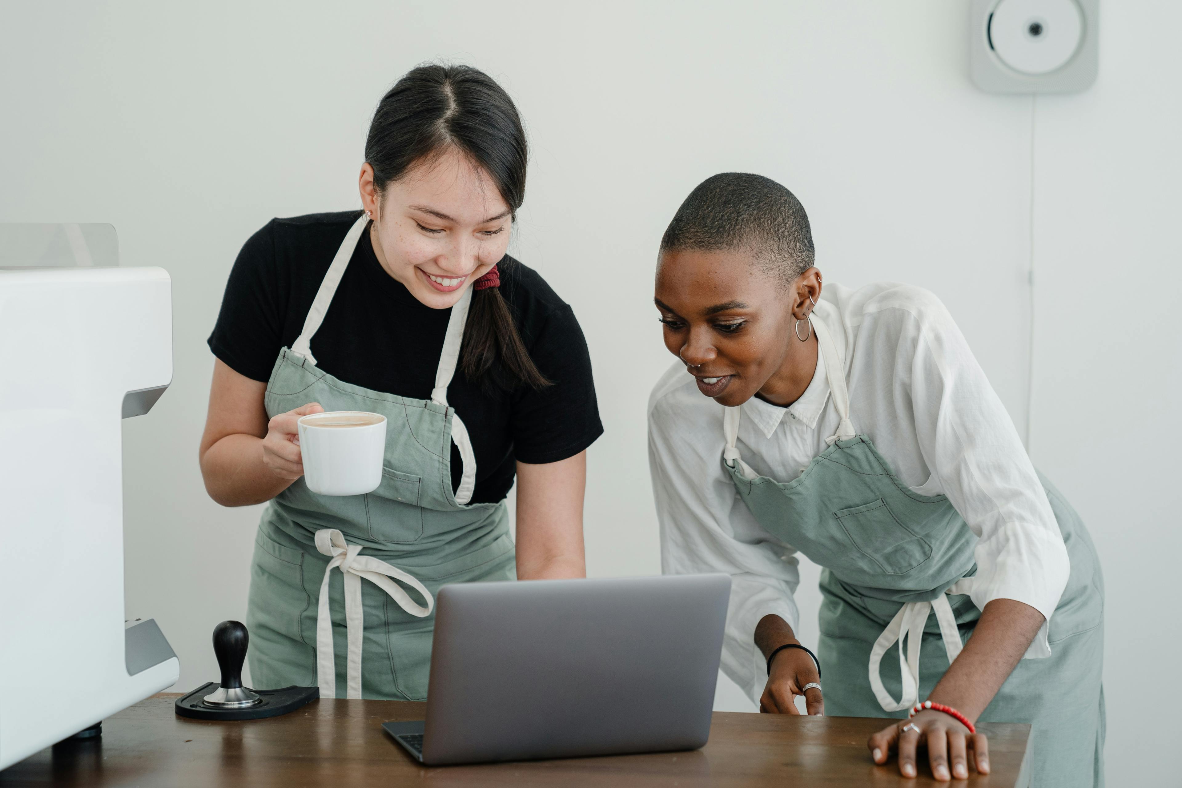 Restaurant staff looking at a laptop. 