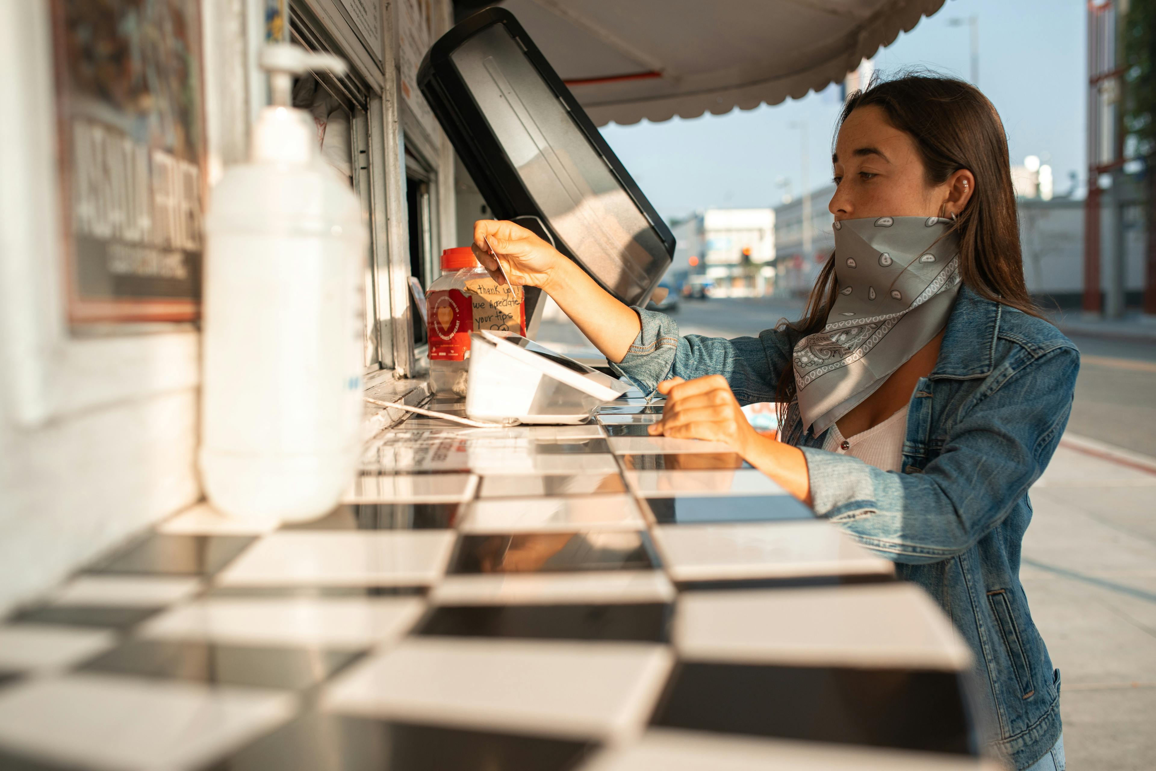 A woman using payment software at a food truck. 