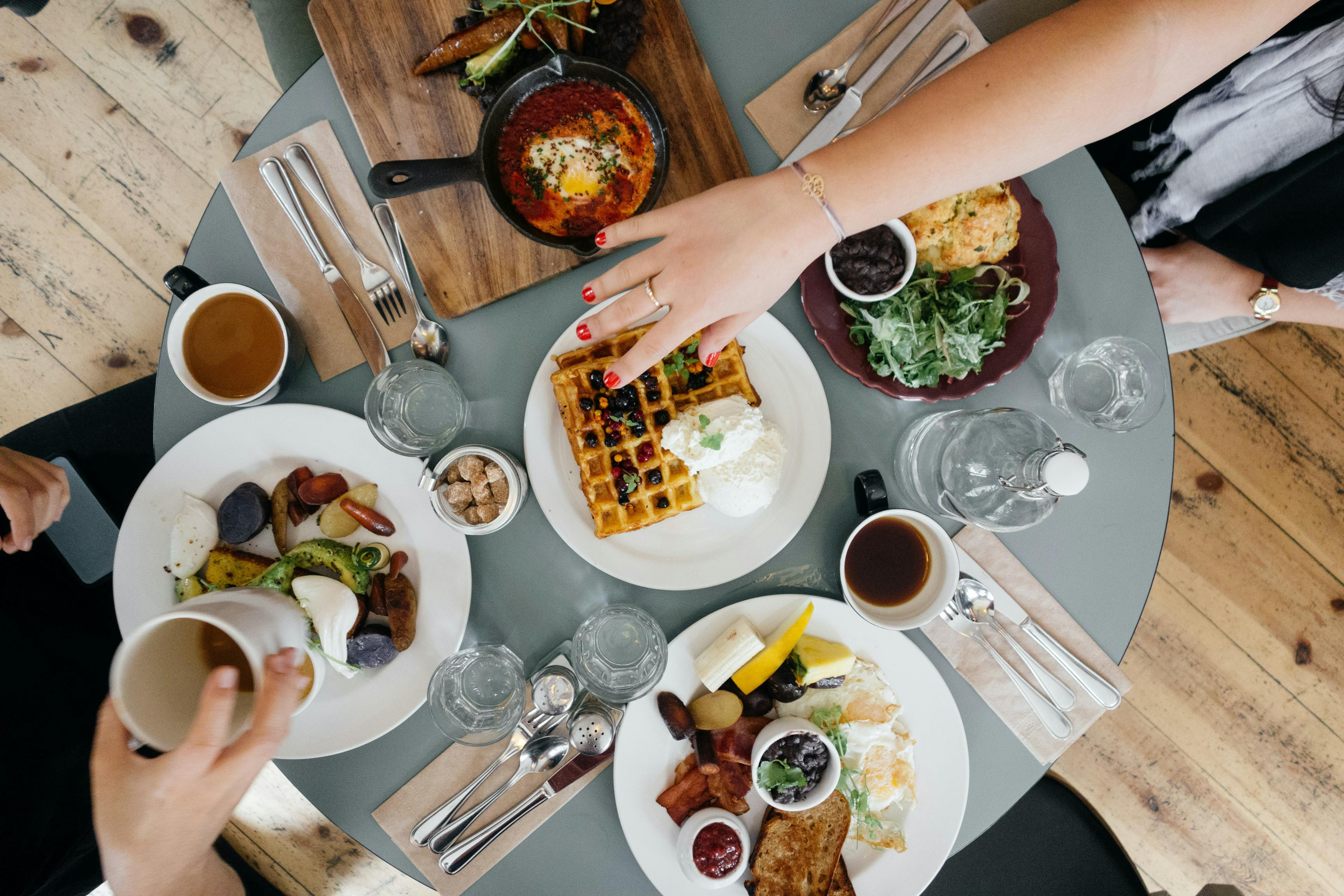 Customers enjoying food at a breakfast restaurant. 