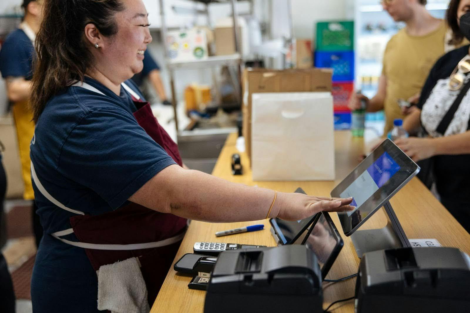 A restaurant staff member using a modern POS system.