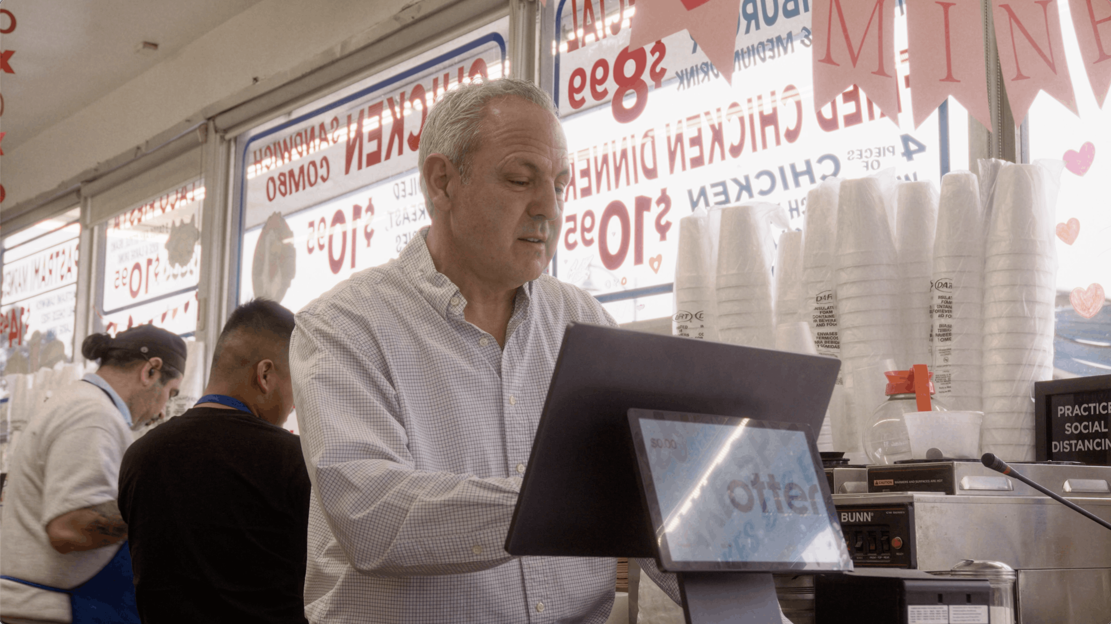 The owner of Jim's Burgers taking an order with Otter's Restaurant Operating System. 