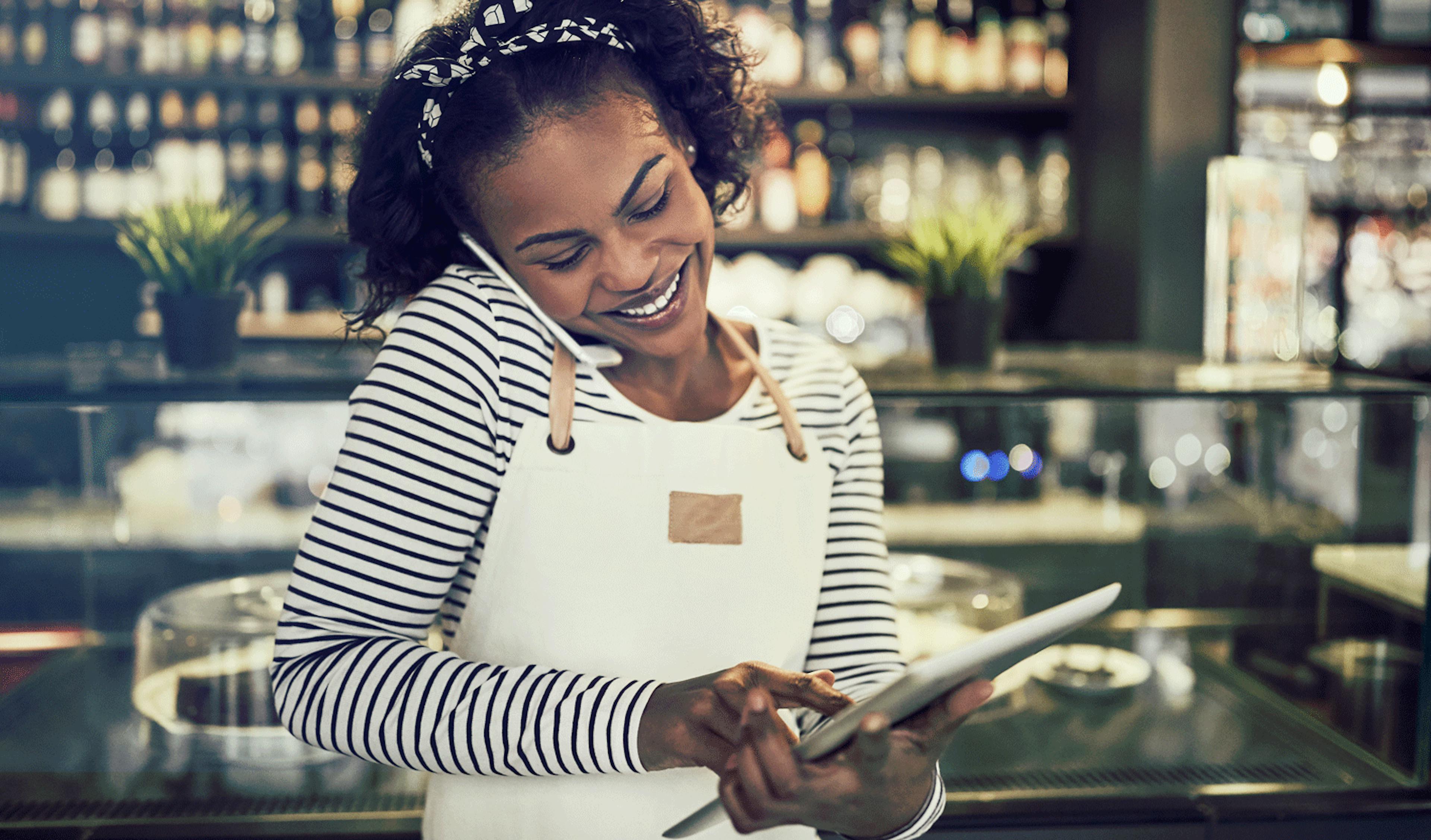 Image of a restaurant employee taking an phone order and inputting it into her smart POS