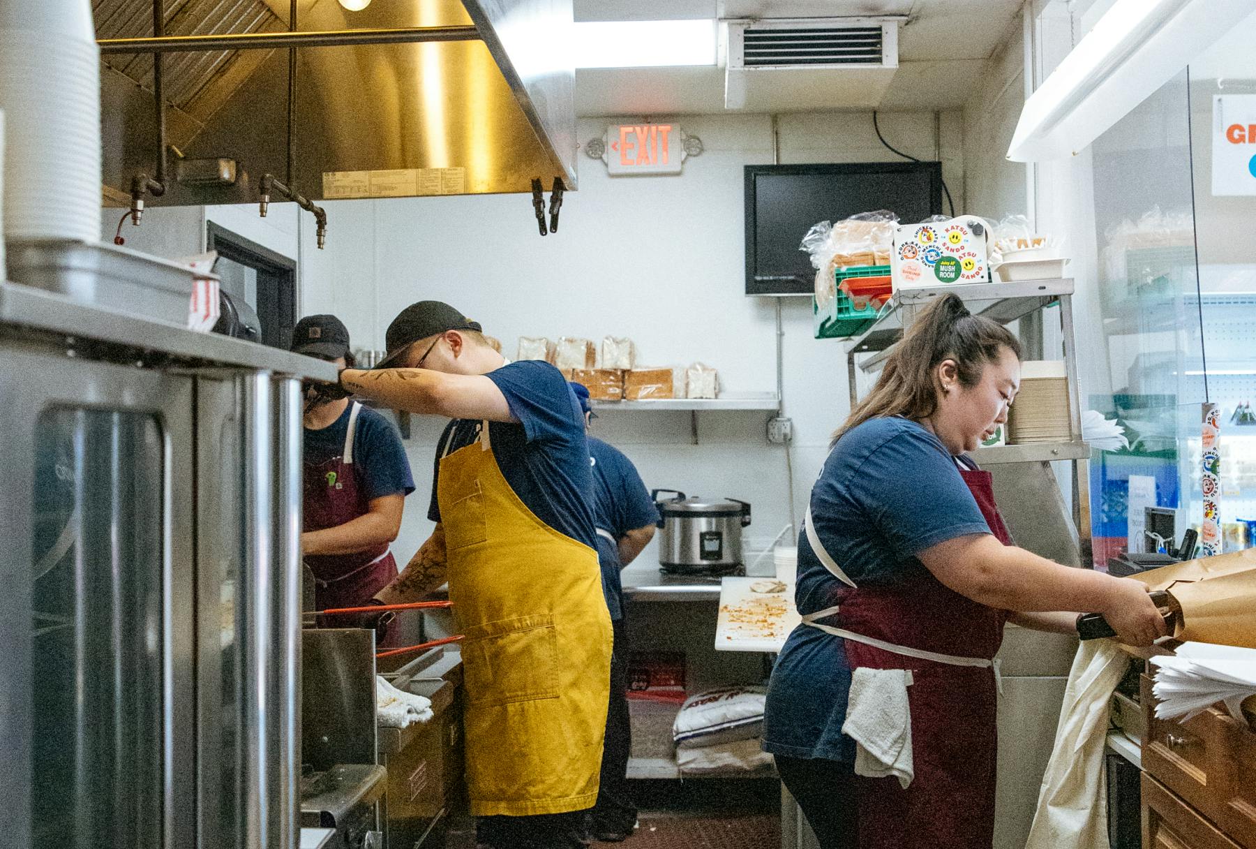 Restaurant staff members cooking in a kitchen.
