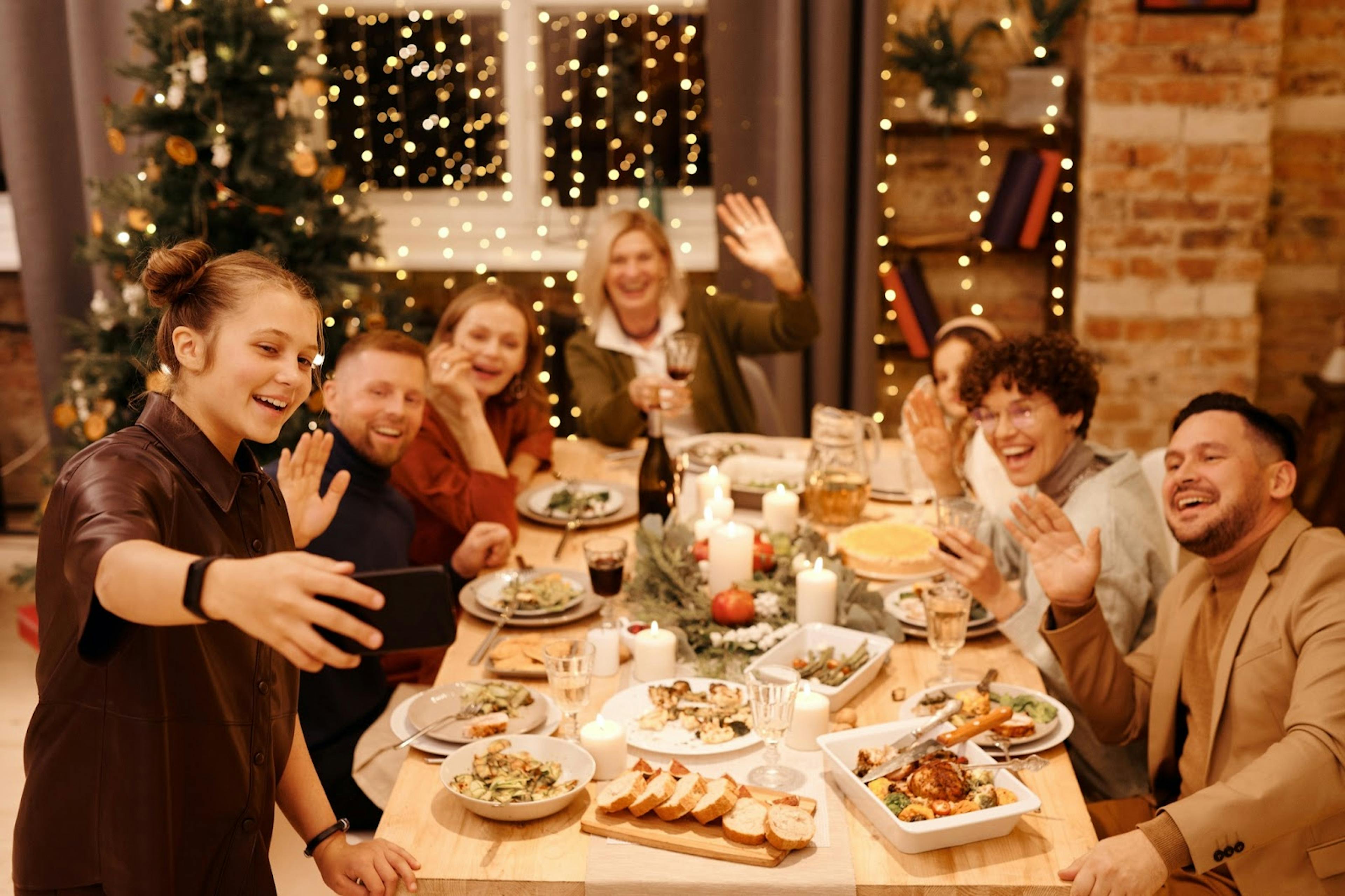 Image of a group of friends taking a selfie while celebrating the holidays at a restaurant 