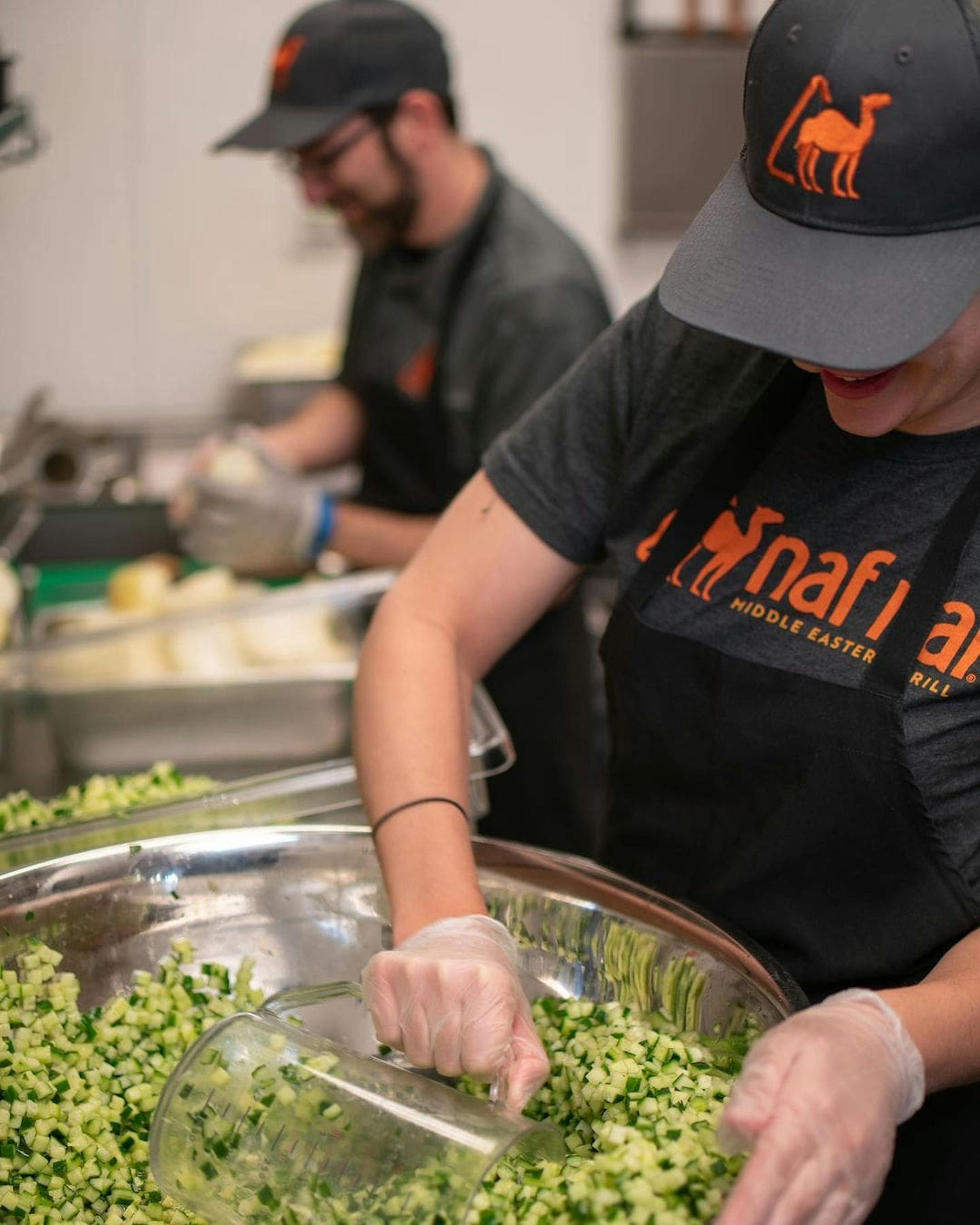 Some employees preparing food at Naf Naf Middle Eastern Grill.