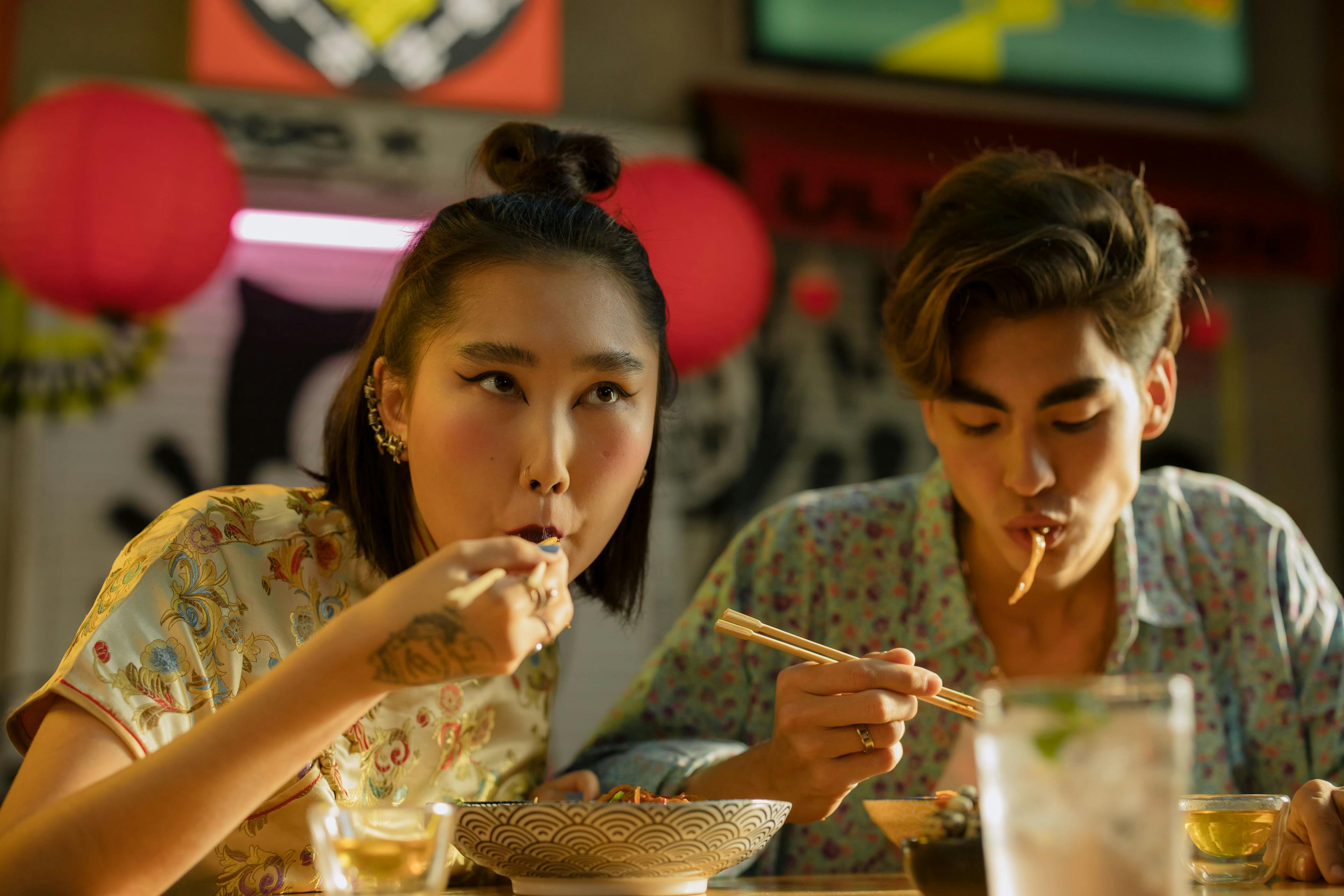 Influencers eating Chinese food at a restaurant.
