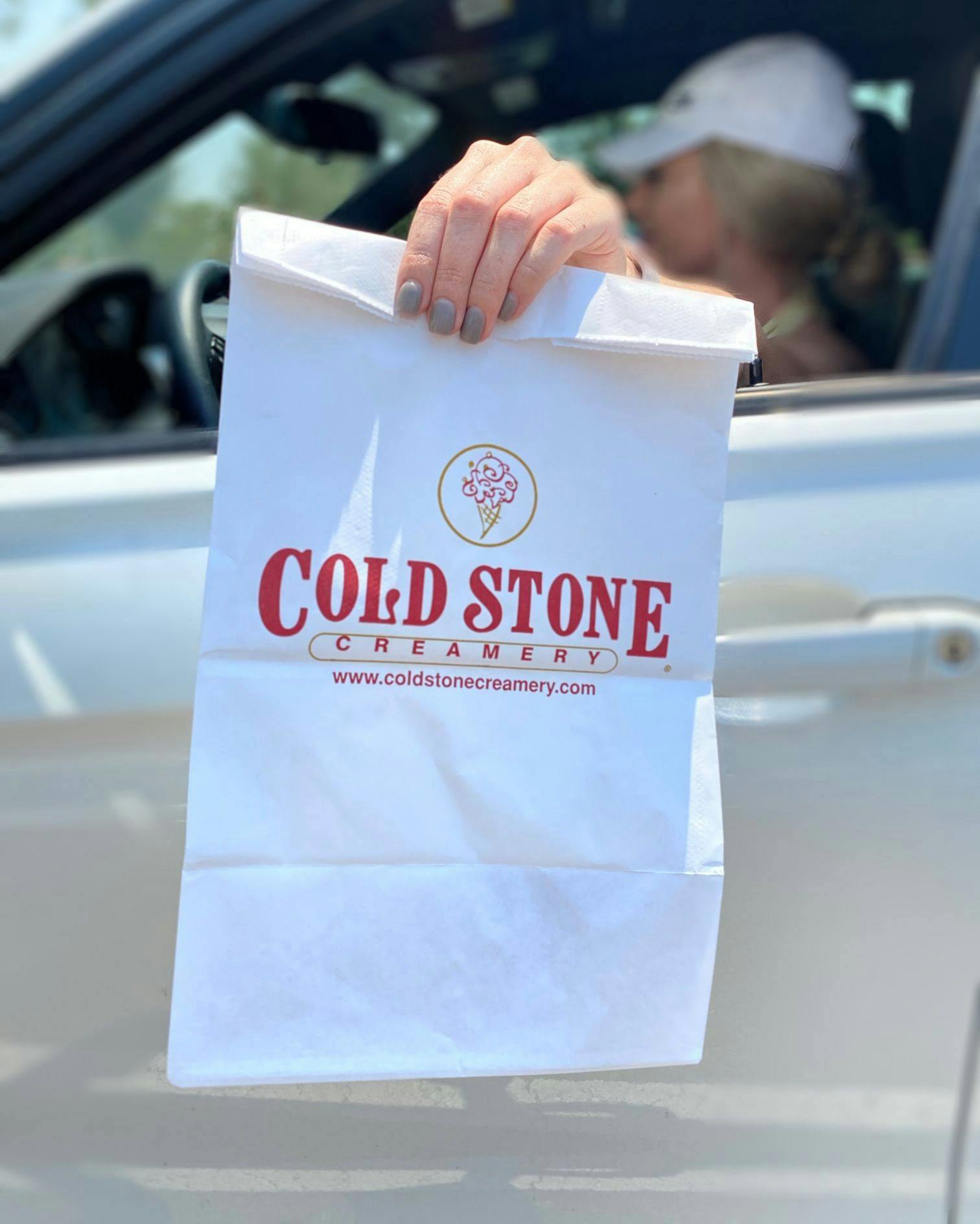 Image of delivery driver holding out a Cold Stone bag