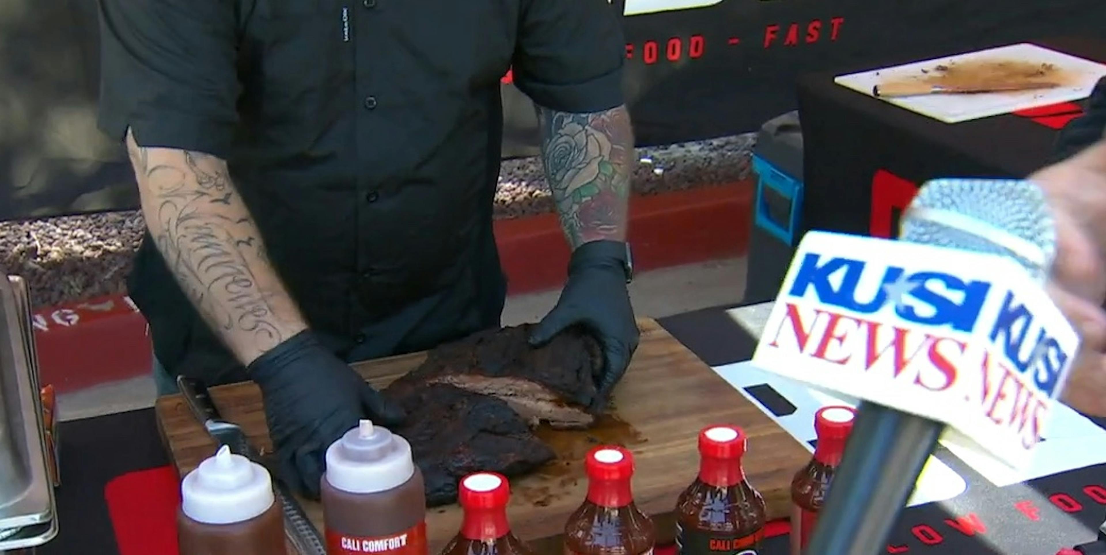 Image of Cali BBQ employee preparing ribs while being interviewed by a news caster