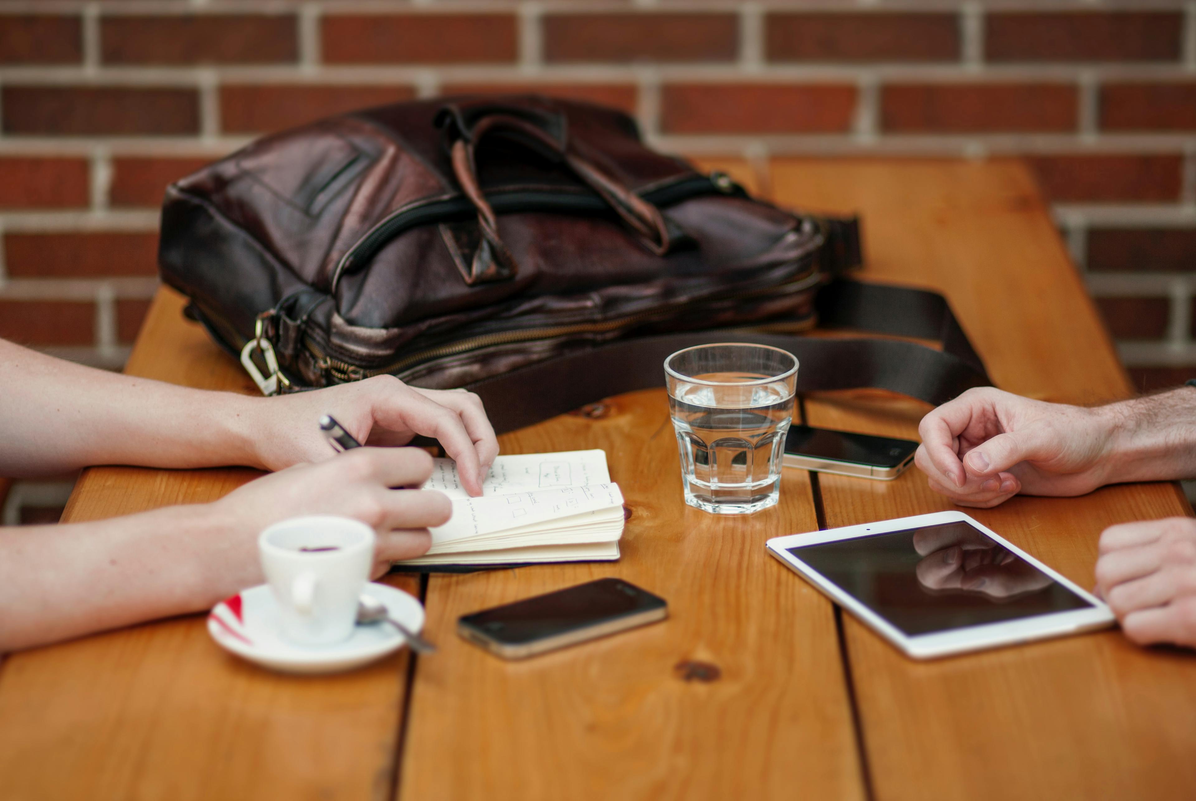 People using technology at a cafe.