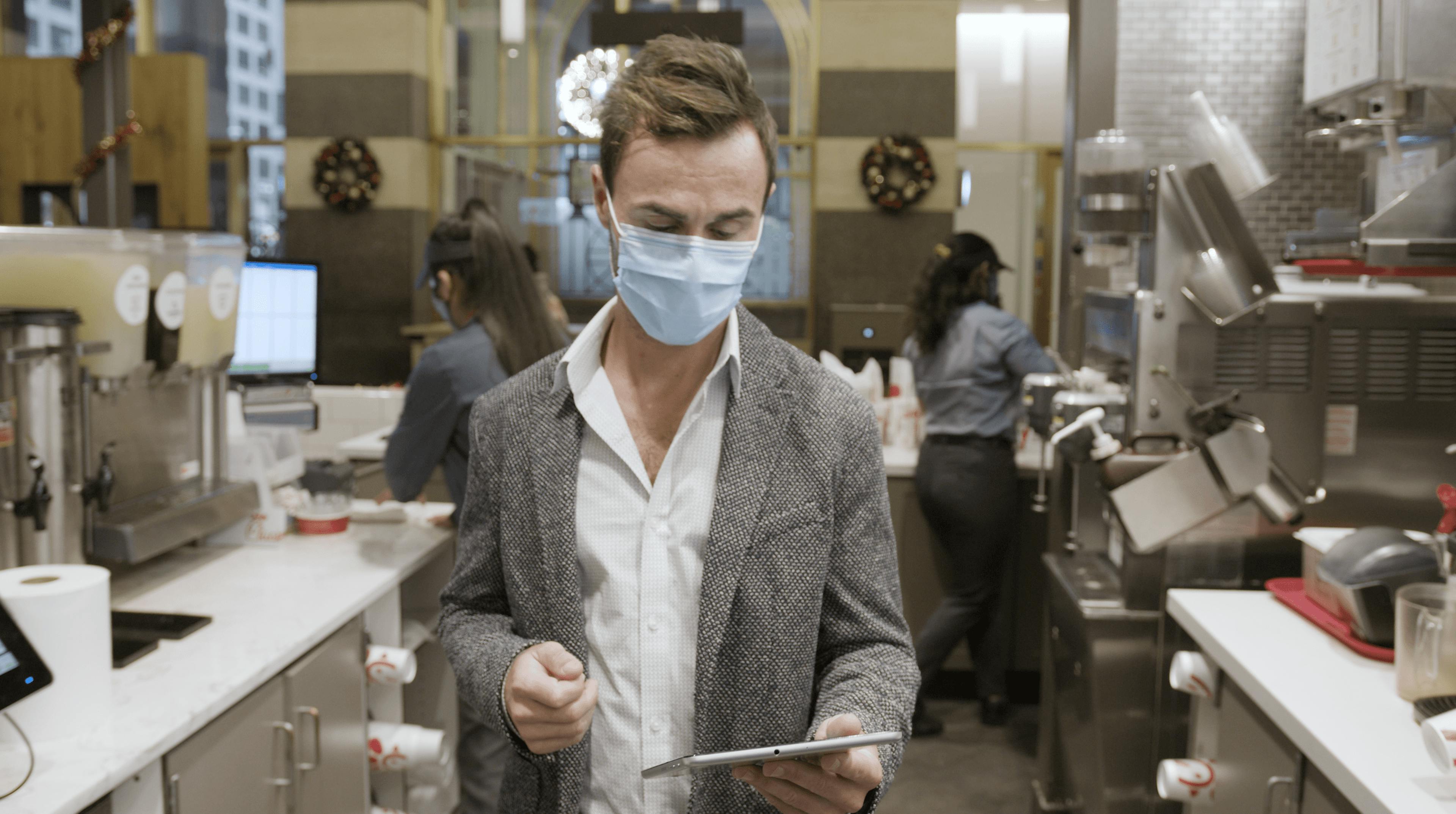 Image of chain restaurant manager looking at his Otter tablet while in the kitchen