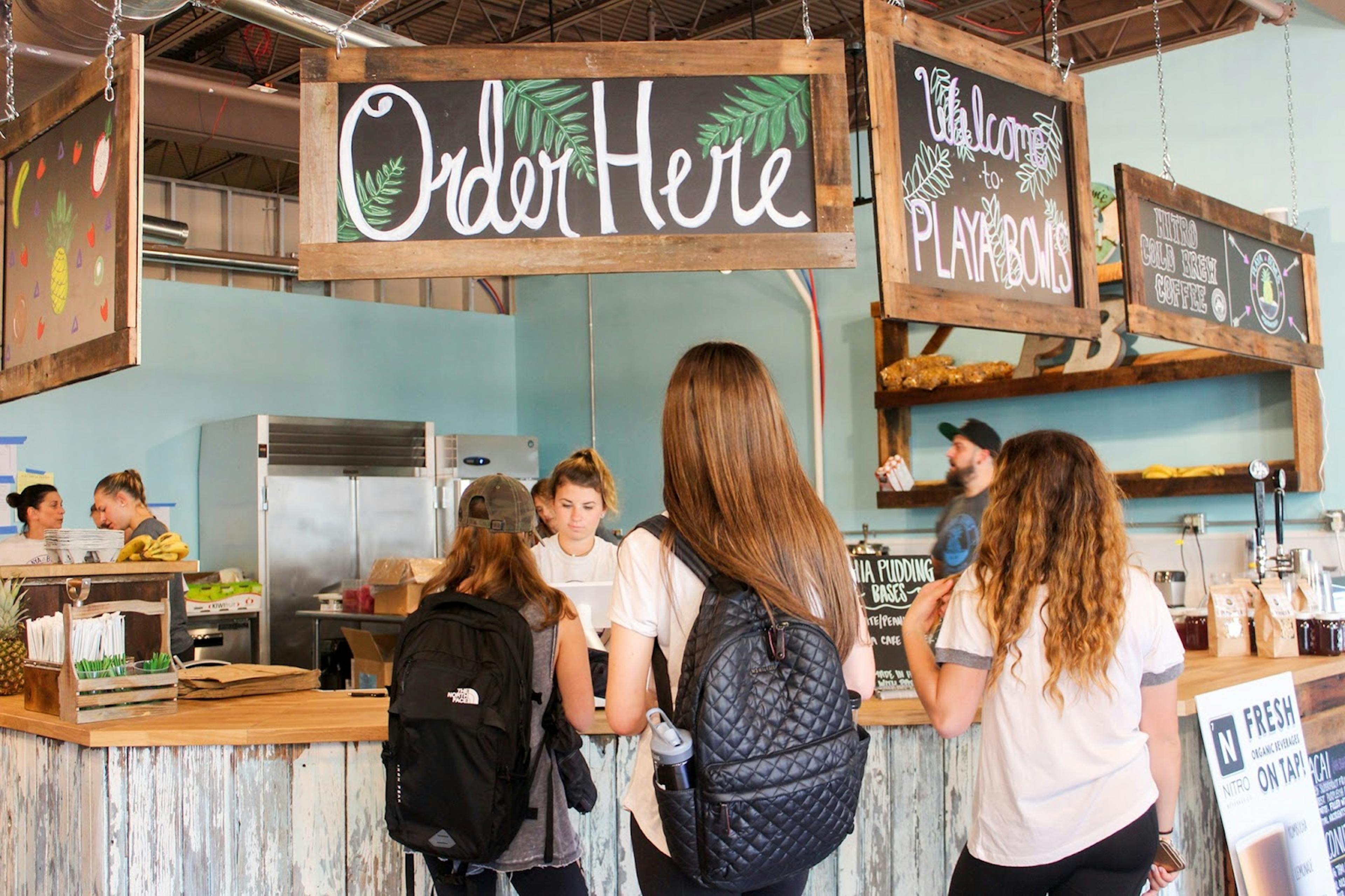 Image of three guests ordering smoothies at a Playa Bowls location