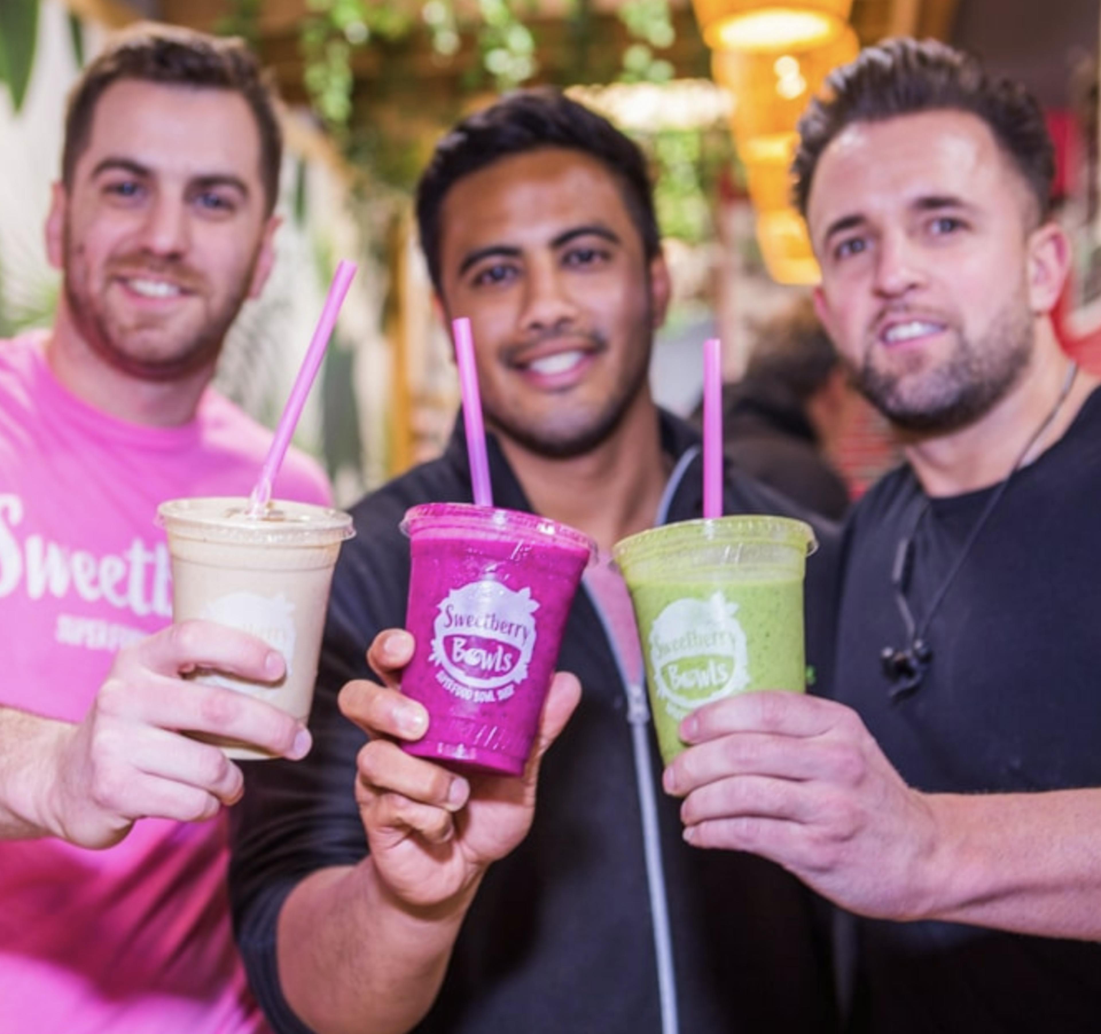 Image of Desi Saran and two other Sweetberry employees cheersing their smoothies