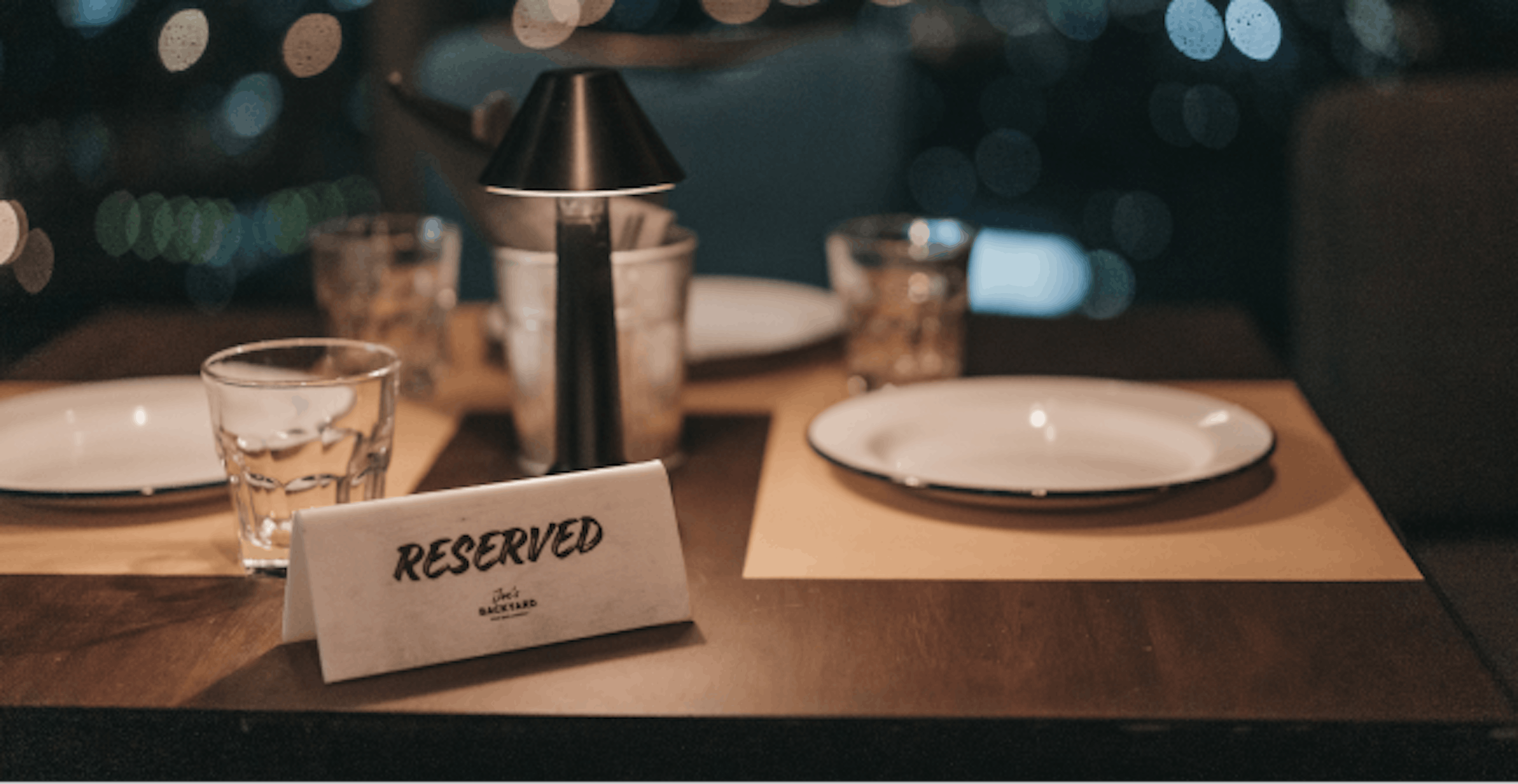 Image of a "reserved" tag sitting on top of a table at a restaurant 