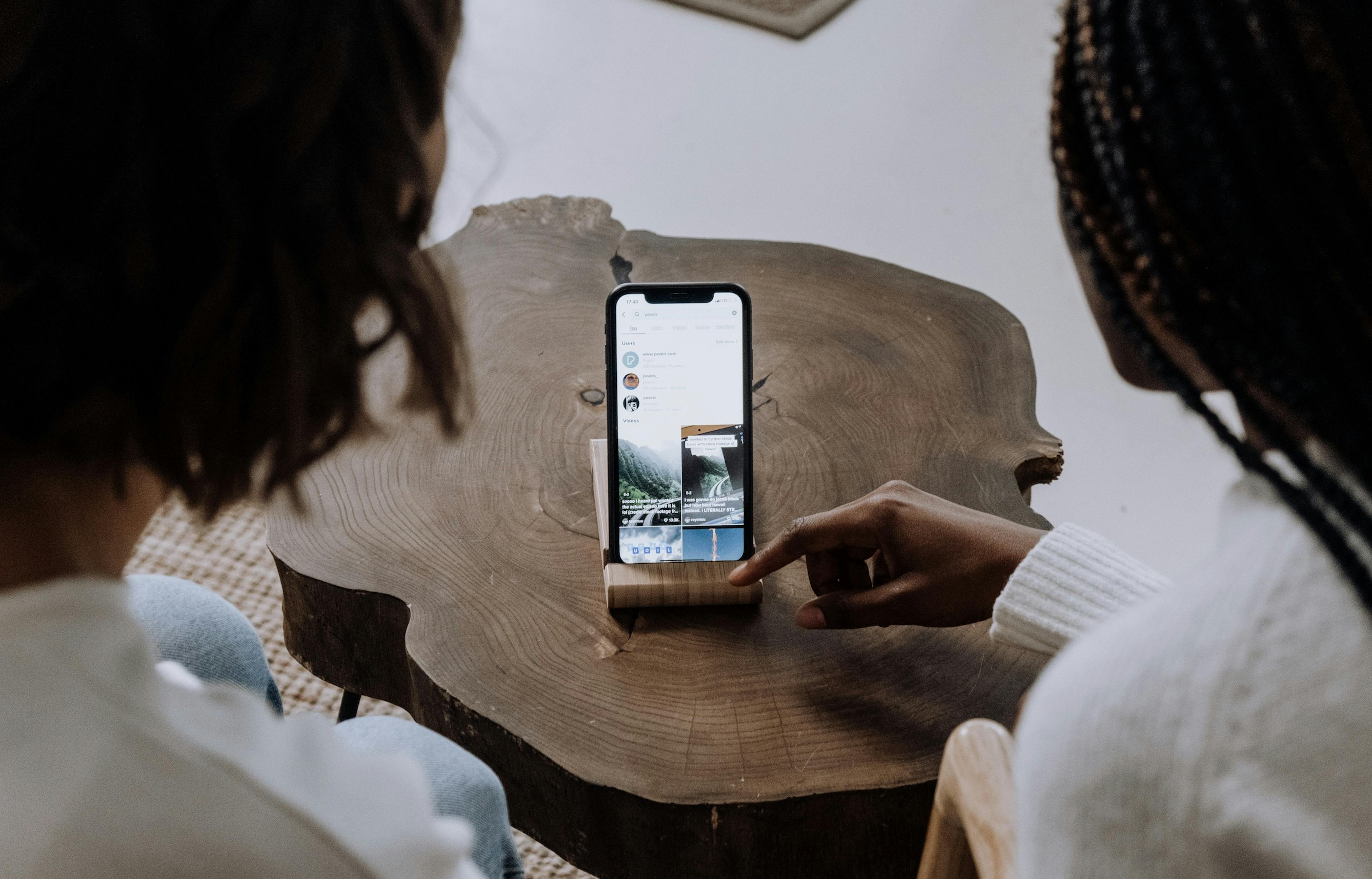 Image of two women scrolling through TikTok at a restaurant