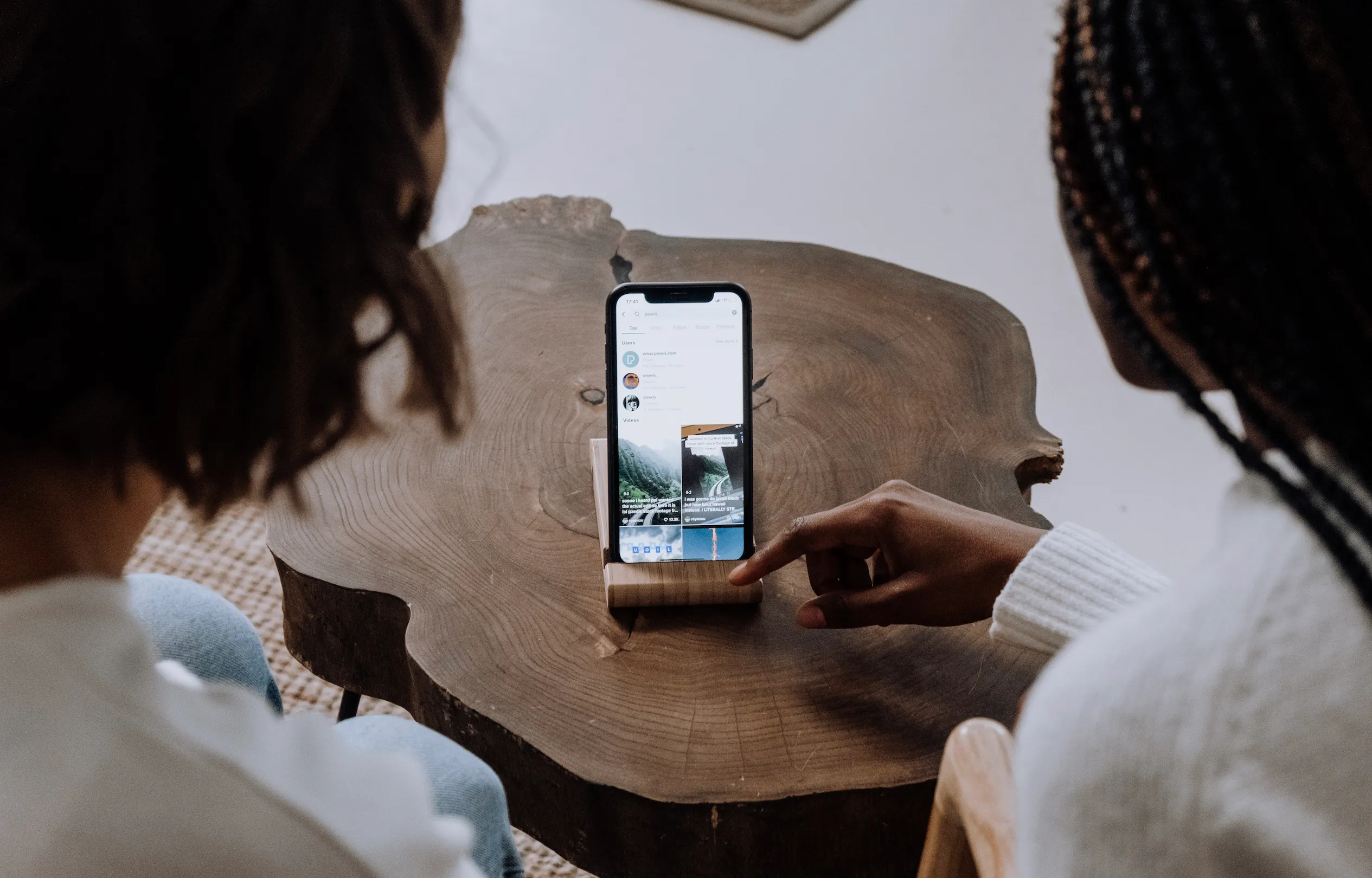 Image of two women scrolling through TikTok at a restaurant