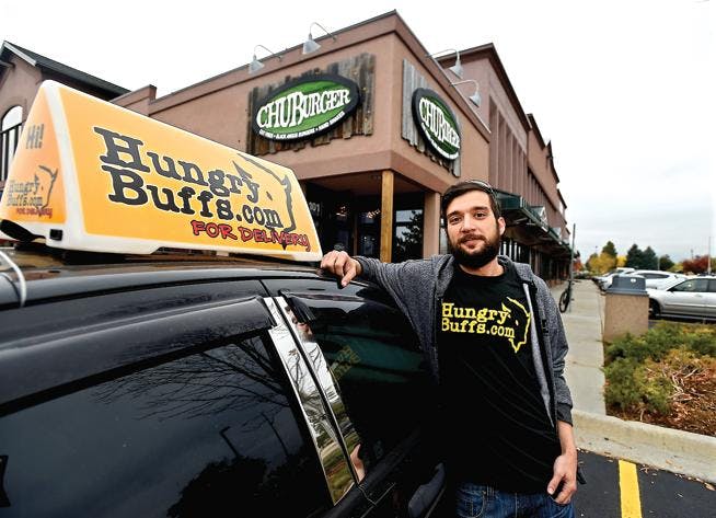 Image of LoDel founder with his arm on top of a delivery courier's vehicle