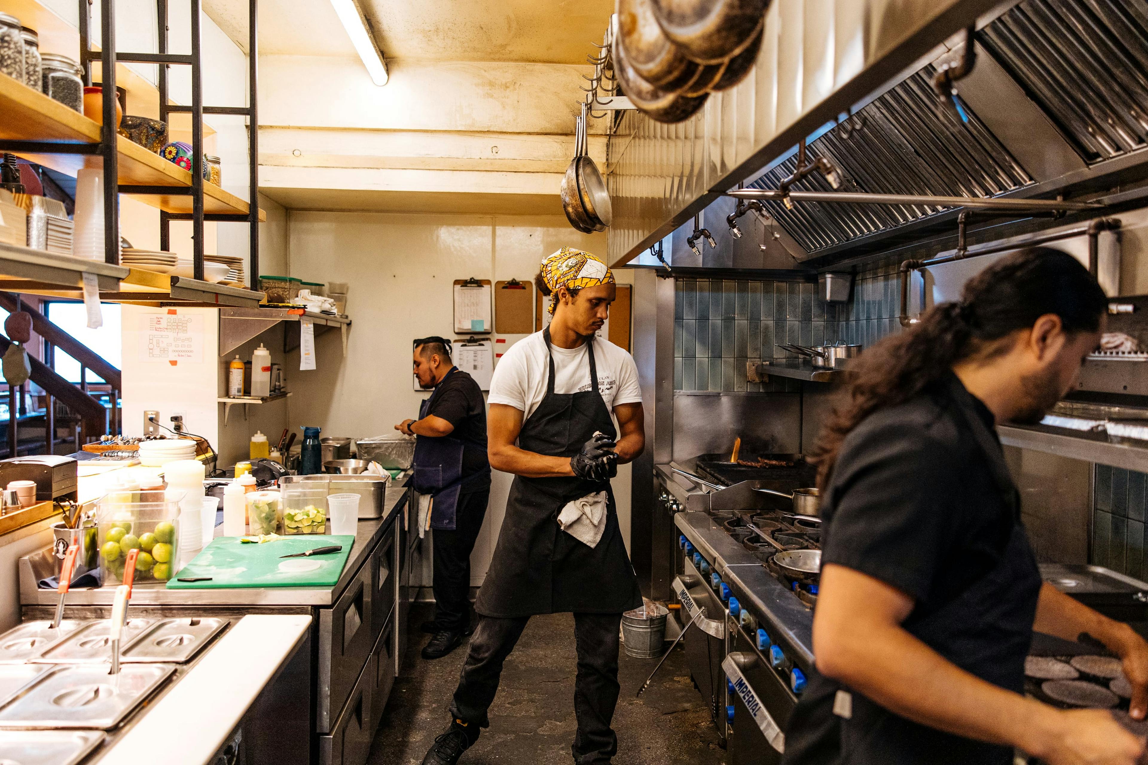 Image of three restaurant employees working in the kitchen