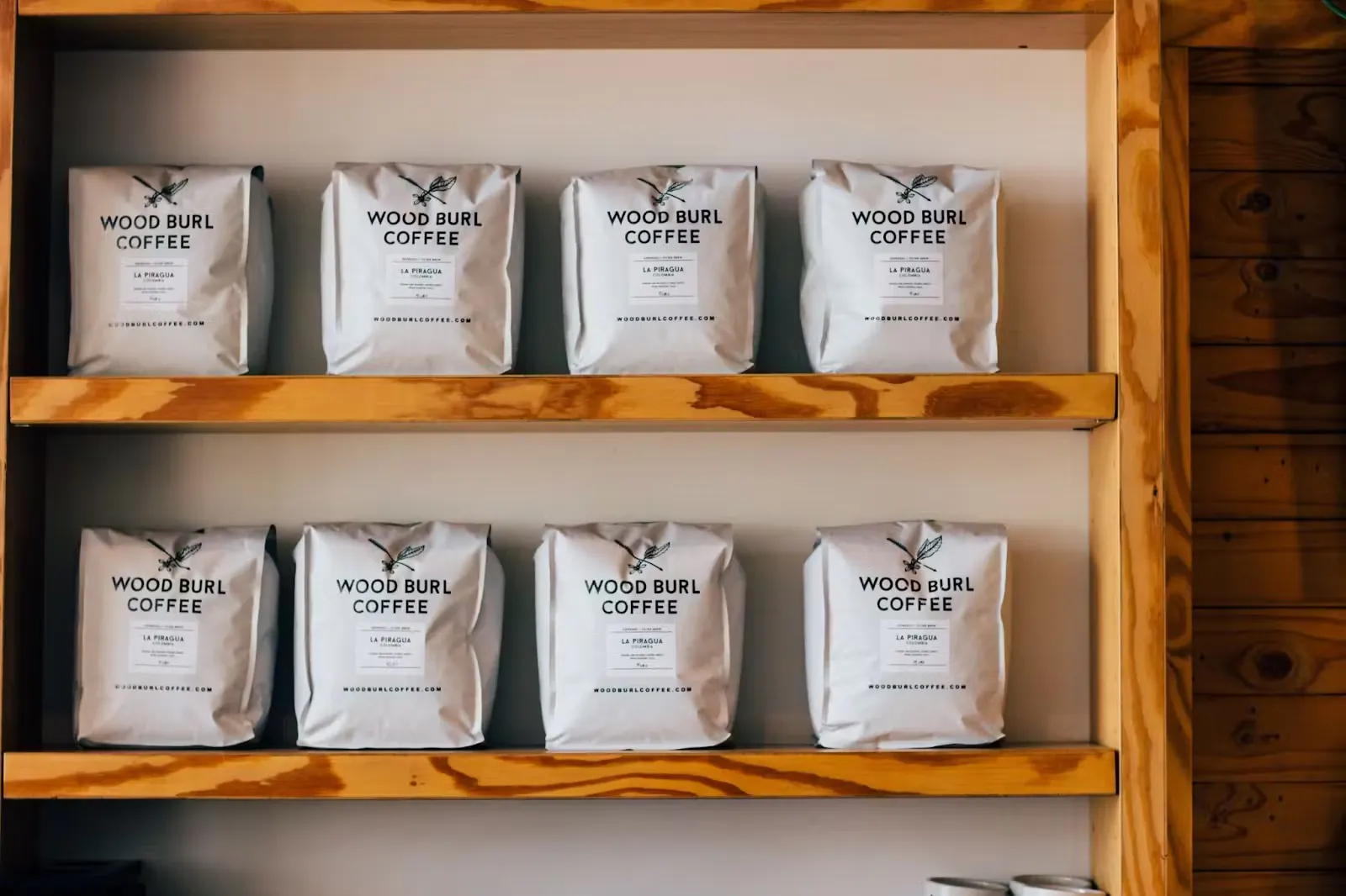 Packaged coffee stacked neatly on a shelf. 
