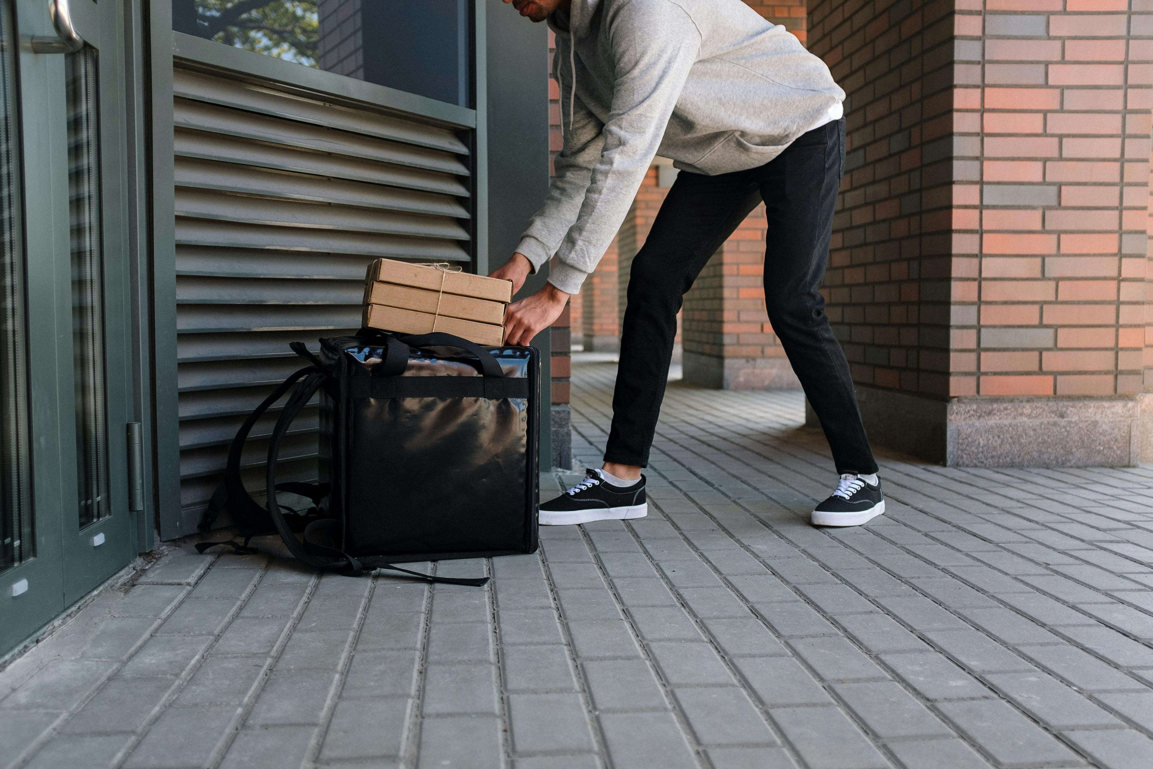 Image of a food delivery courier dropping off an order to a customer