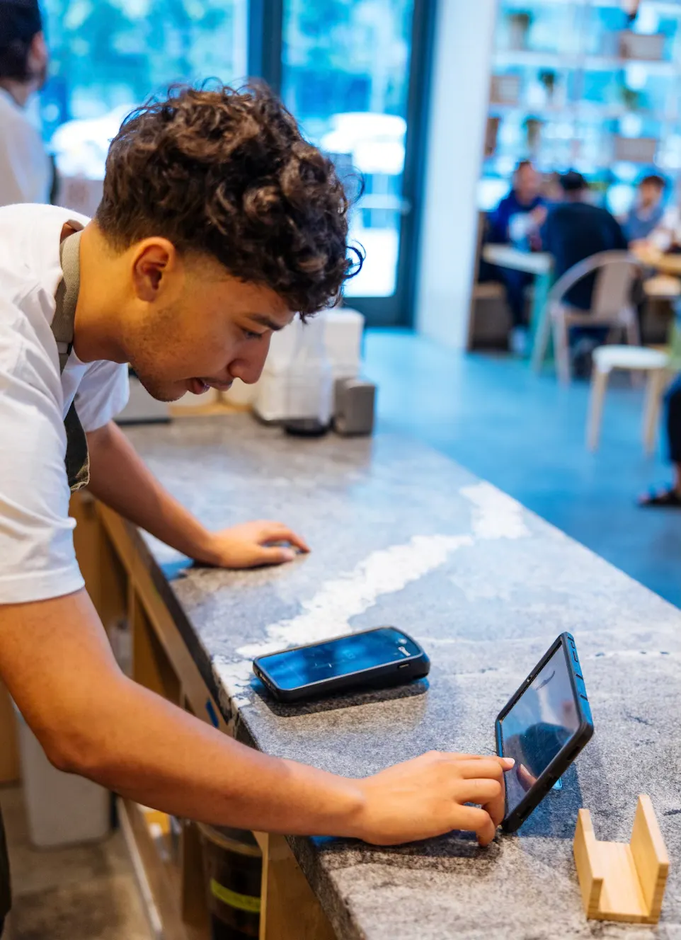 Image of a restaurant employee managing orders on the tablet in his front-of-house