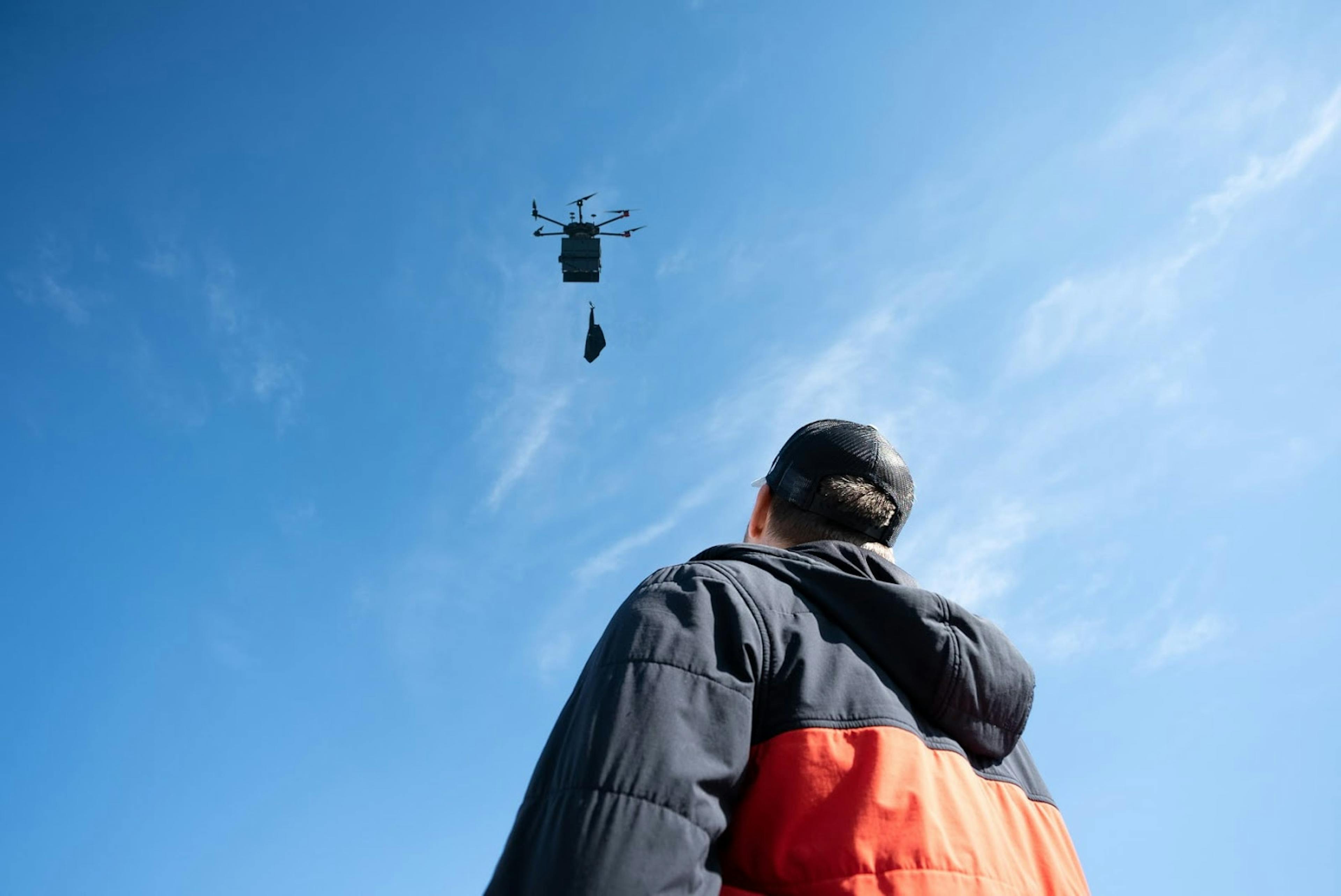 Image of a man outside looking up at a drone