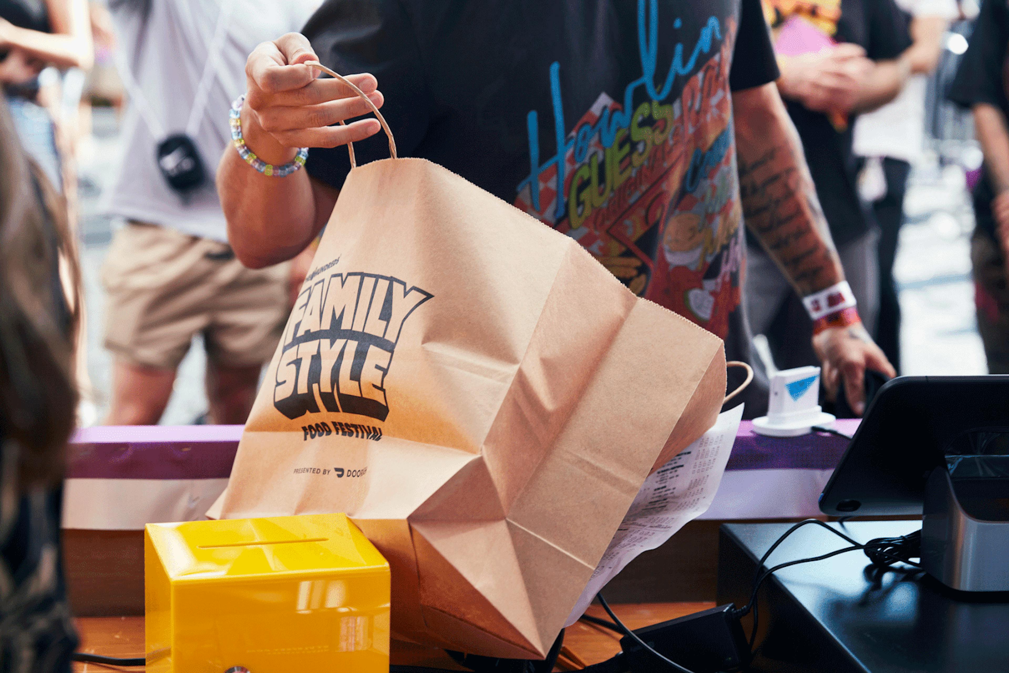 Image of someone packing food delivery into a branded bag