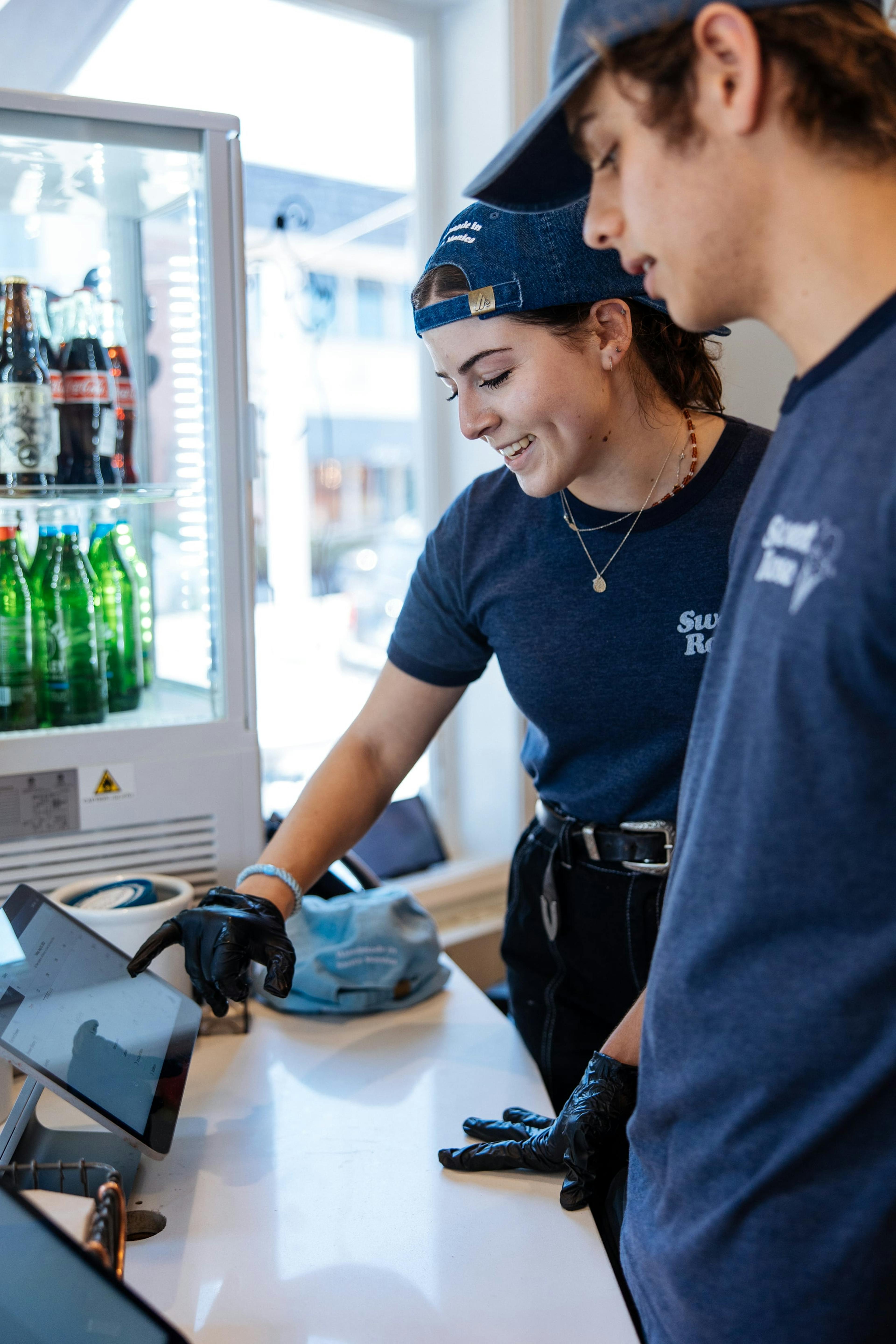 Image of two young people looking at an order in the POS system at the restaurant they work at