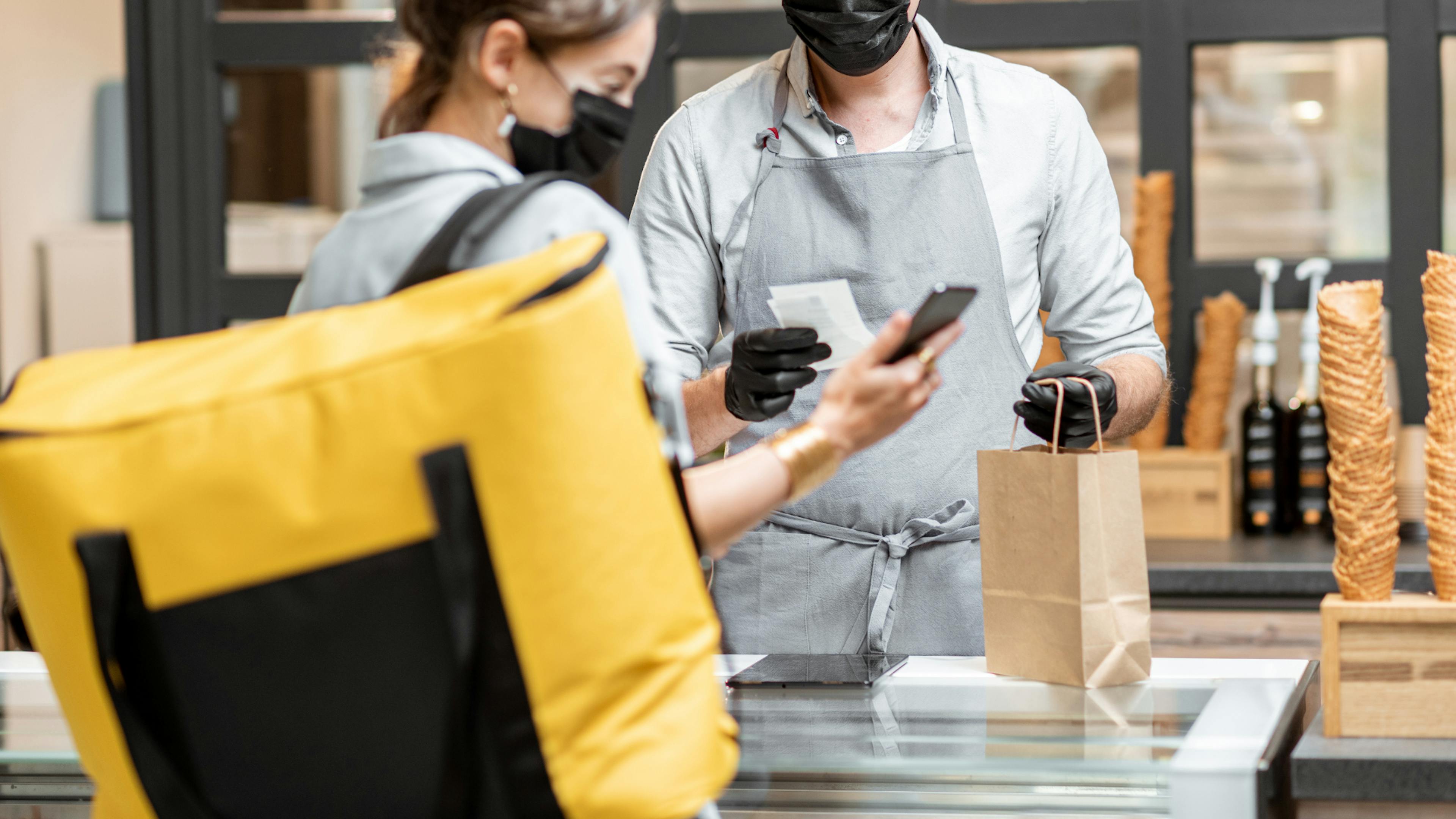 Image of restaurant staff members looking at new orders coming in 