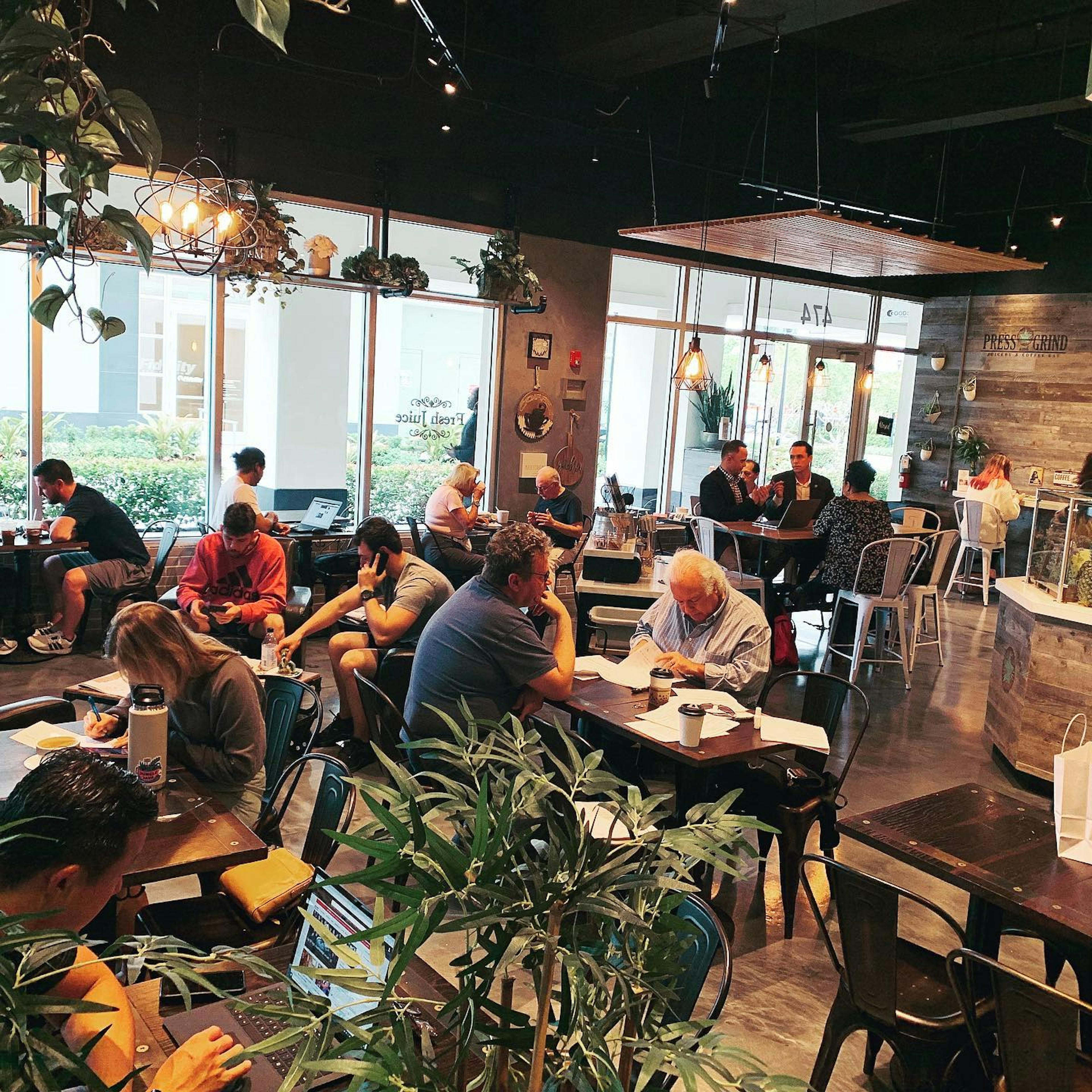 Image of people working, talking, and relaxing at Press & Grind Cafe