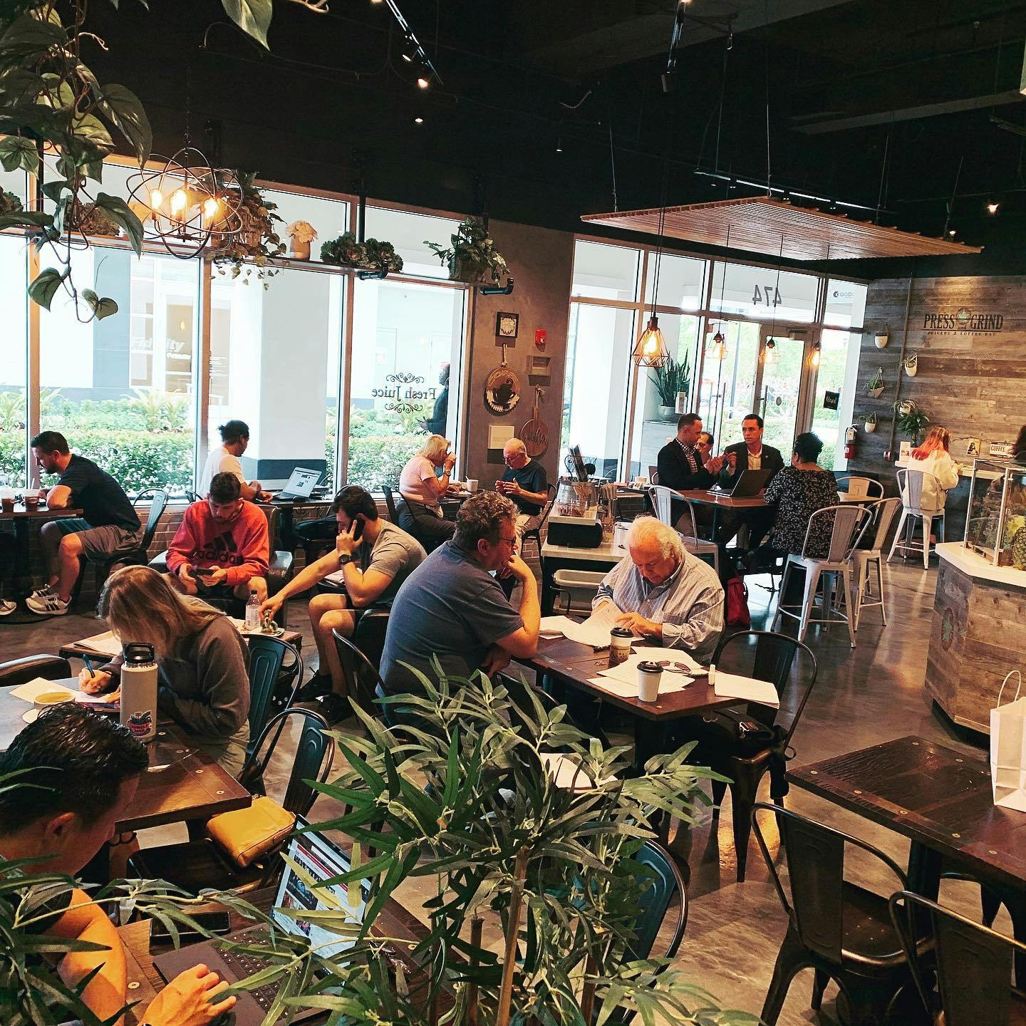 Image of people working, talking, and relaxing at Press & Grind Cafe