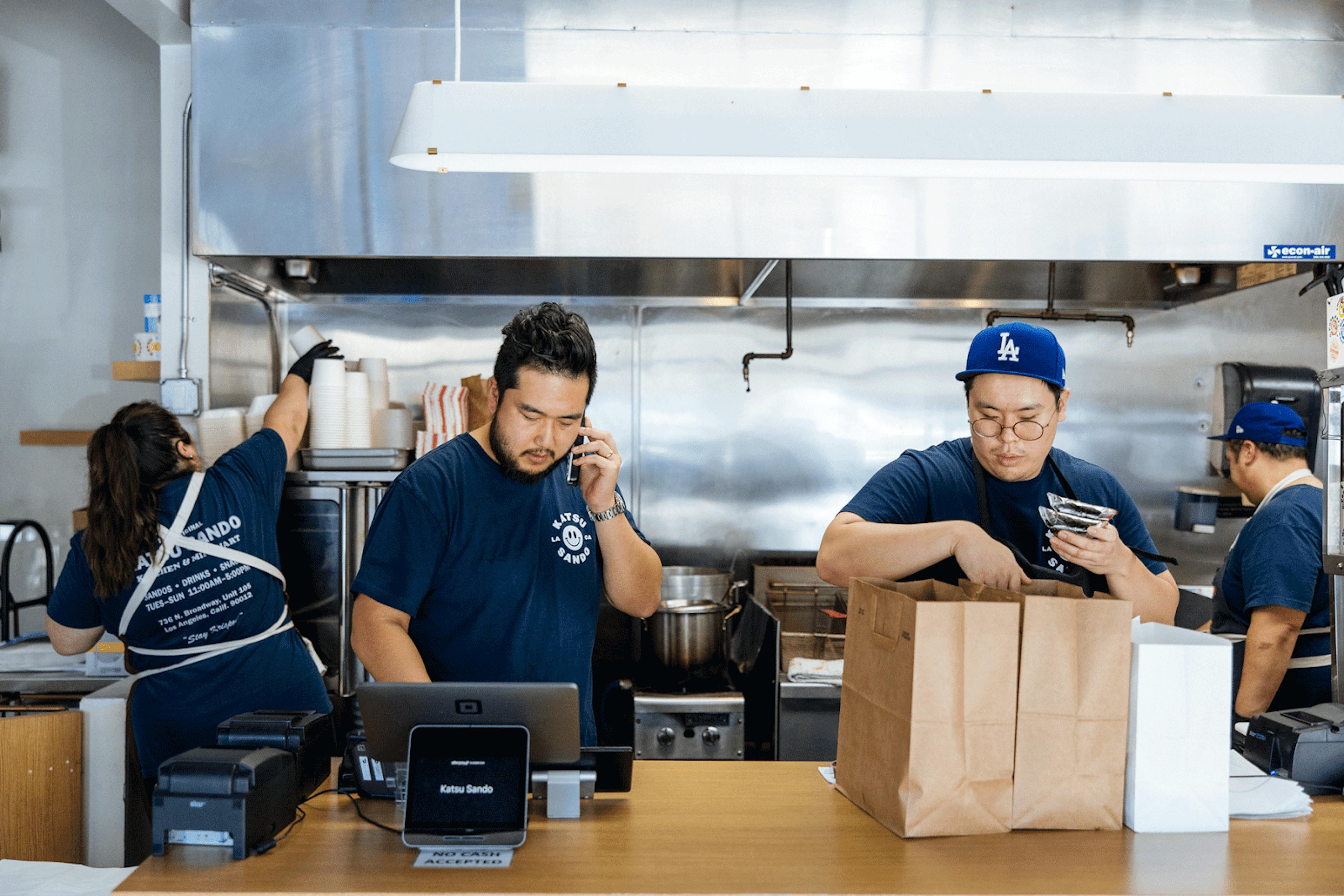 Image of two restaurant workers packing delivery orders